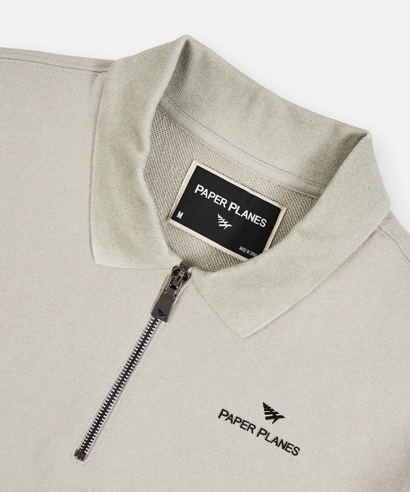 Paper Planes Lockup quarter zip polo in grey with heavyweight French Terry cotton, branded zipper, ribbed collar, and signature silicone logo details.