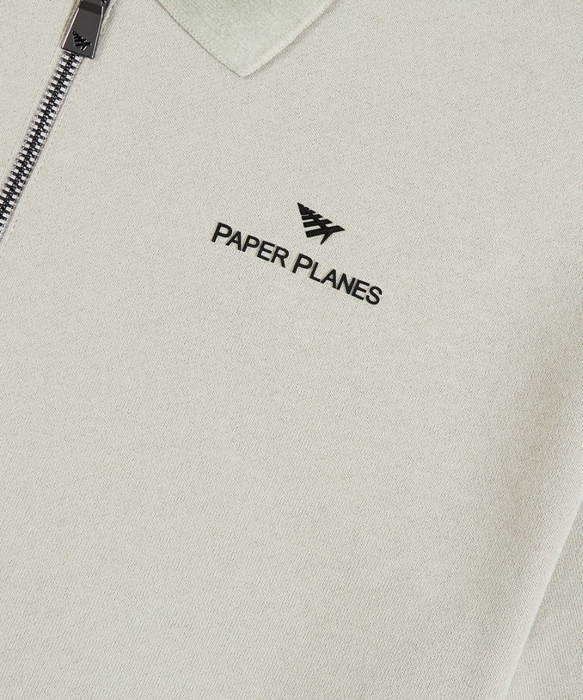 Paper Planes Lockup quarter zip polo in grey with heavyweight French Terry cotton, branded zipper, ribbed collar, and signature silicone logo details.