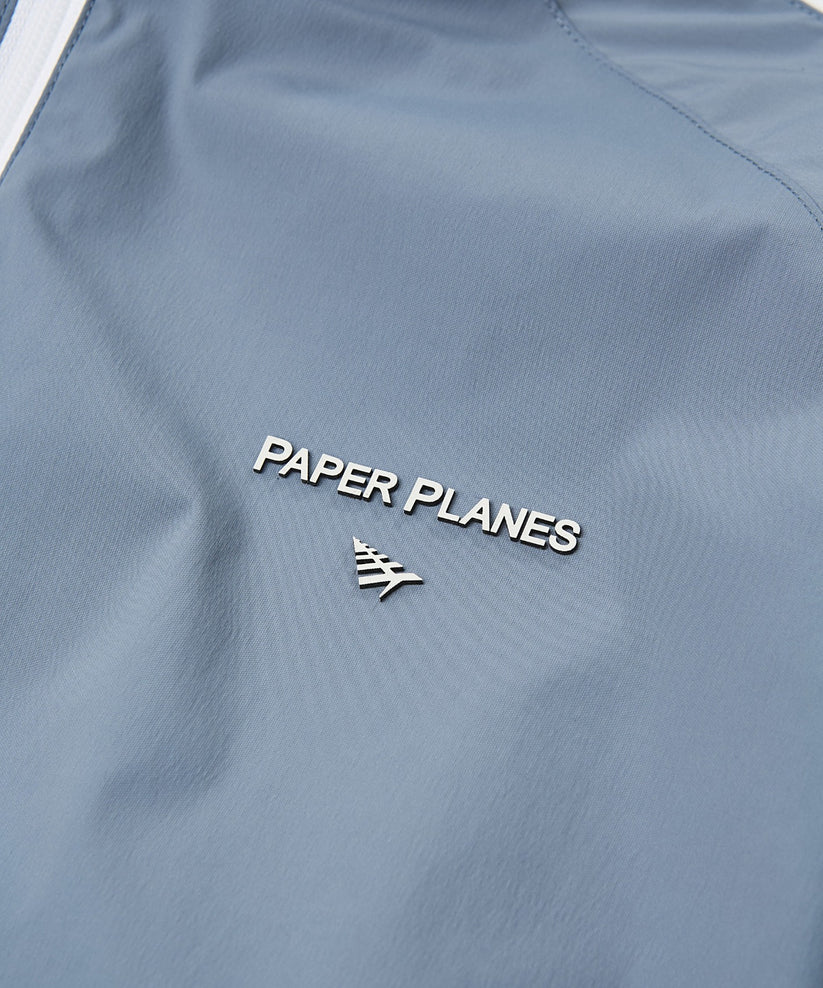 Paper Plane Planes Lounge lightweight track jacket with raglan sleeves, zip pockets, and water-resistant nylon fabric.