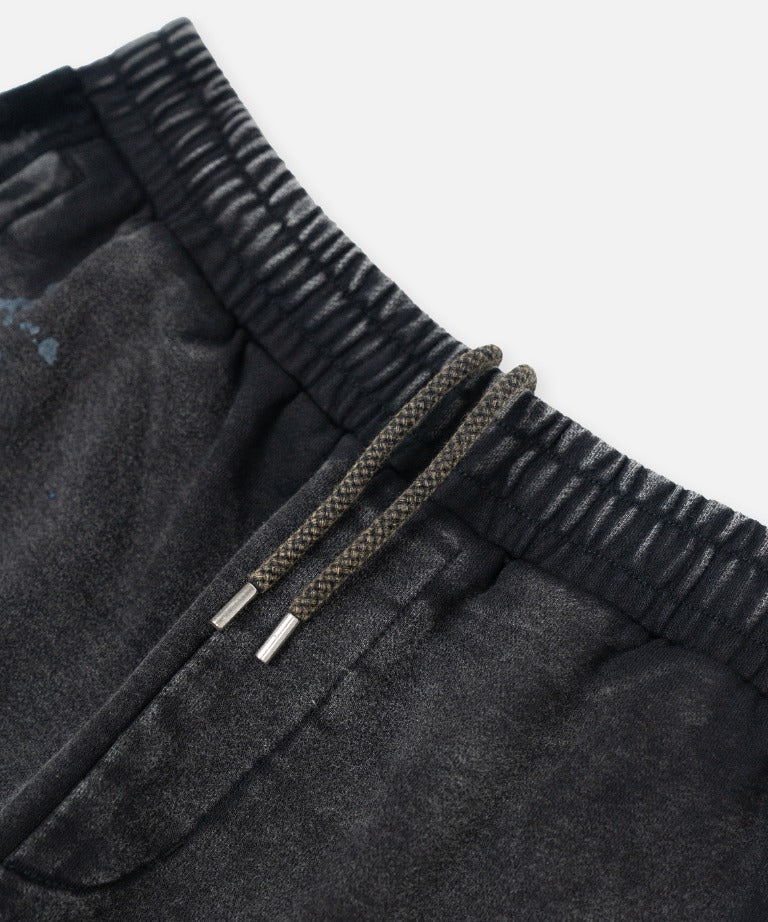 Paper Plane black heavyweight sweatpants with splatter effect, zippered pockets, and elastic waistband.