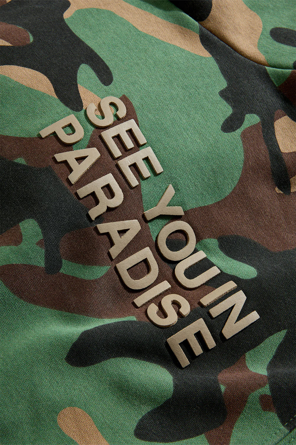 The SYIP Pullover Hoodie in Vintage Camo brings a sharp, technical look with everyday comfort. Designed in a classic hoodie silhouette, it features an all-over camo print and tonal high-density graphics on the chest and back. Made from combed cotton low-shrinkage fleece, this hoodie delivers softness, durability, and a crisp fit. Finished with ribbed cuffs, a ribbed waistband, and a front kangaroo pocket, it pairs perfectly with the matching SYIP Stacked Sweatpants in Vintage Camo.