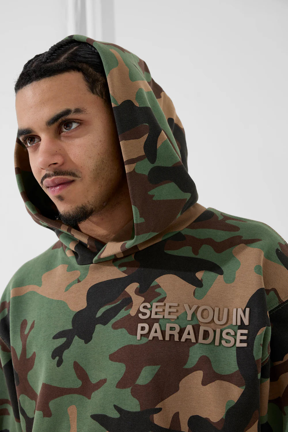 The SYIP Pullover Hoodie in Vintage Camo brings a sharp, technical look with everyday comfort. Designed in a classic hoodie silhouette, it features an all-over camo print and tonal high-density graphics on the chest and back. Made from combed cotton low-shrinkage fleece, this hoodie delivers softness, durability, and a crisp fit. Finished with ribbed cuffs, a ribbed waistband, and a front kangaroo pocket, it pairs perfectly with the matching SYIP Stacked Sweatpants in Vintage Camo.