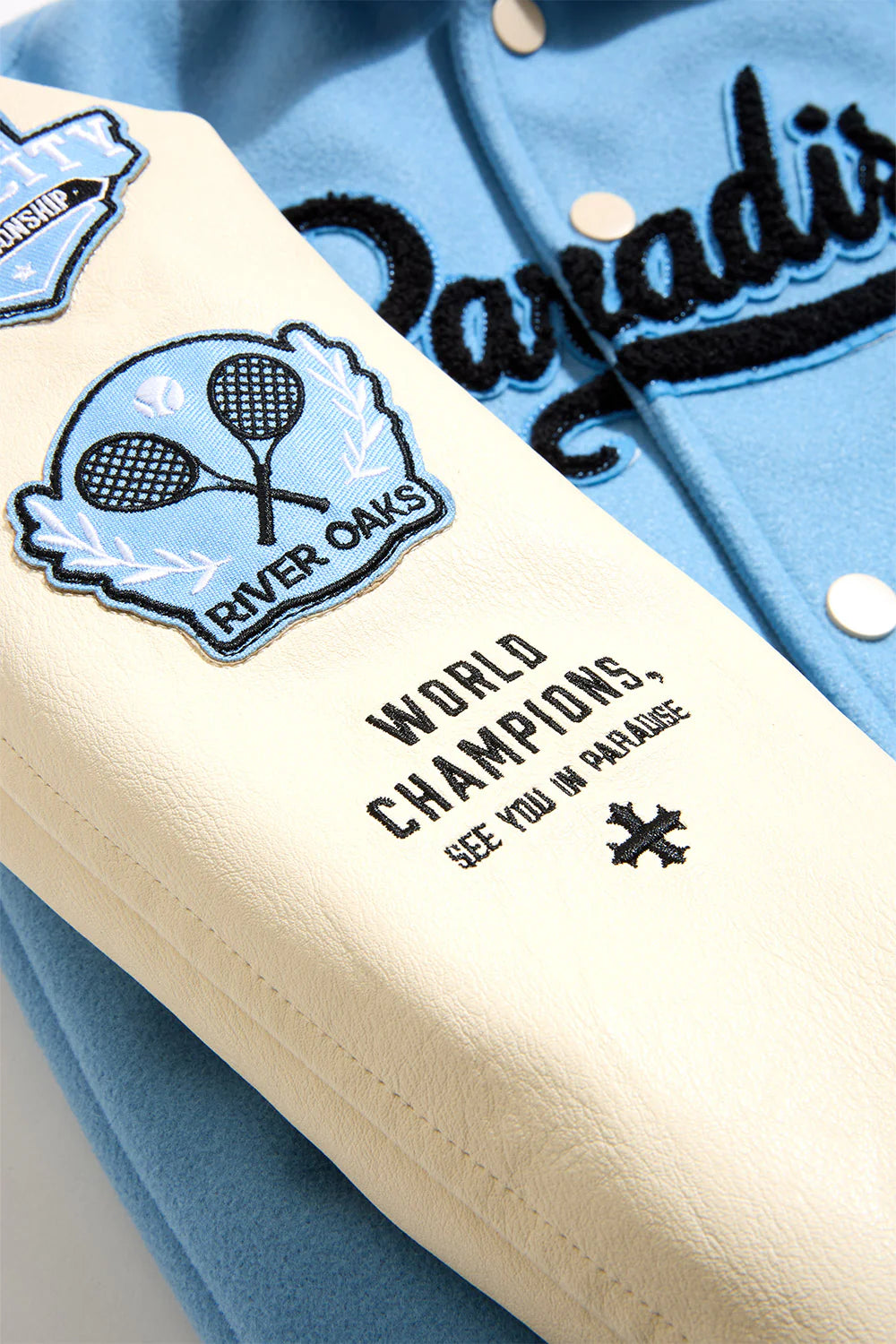 Paradise Team Varsity Jacket in Sky Blue with wool body, vegan leather sleeves, striped ribbed trims, and chenille patches