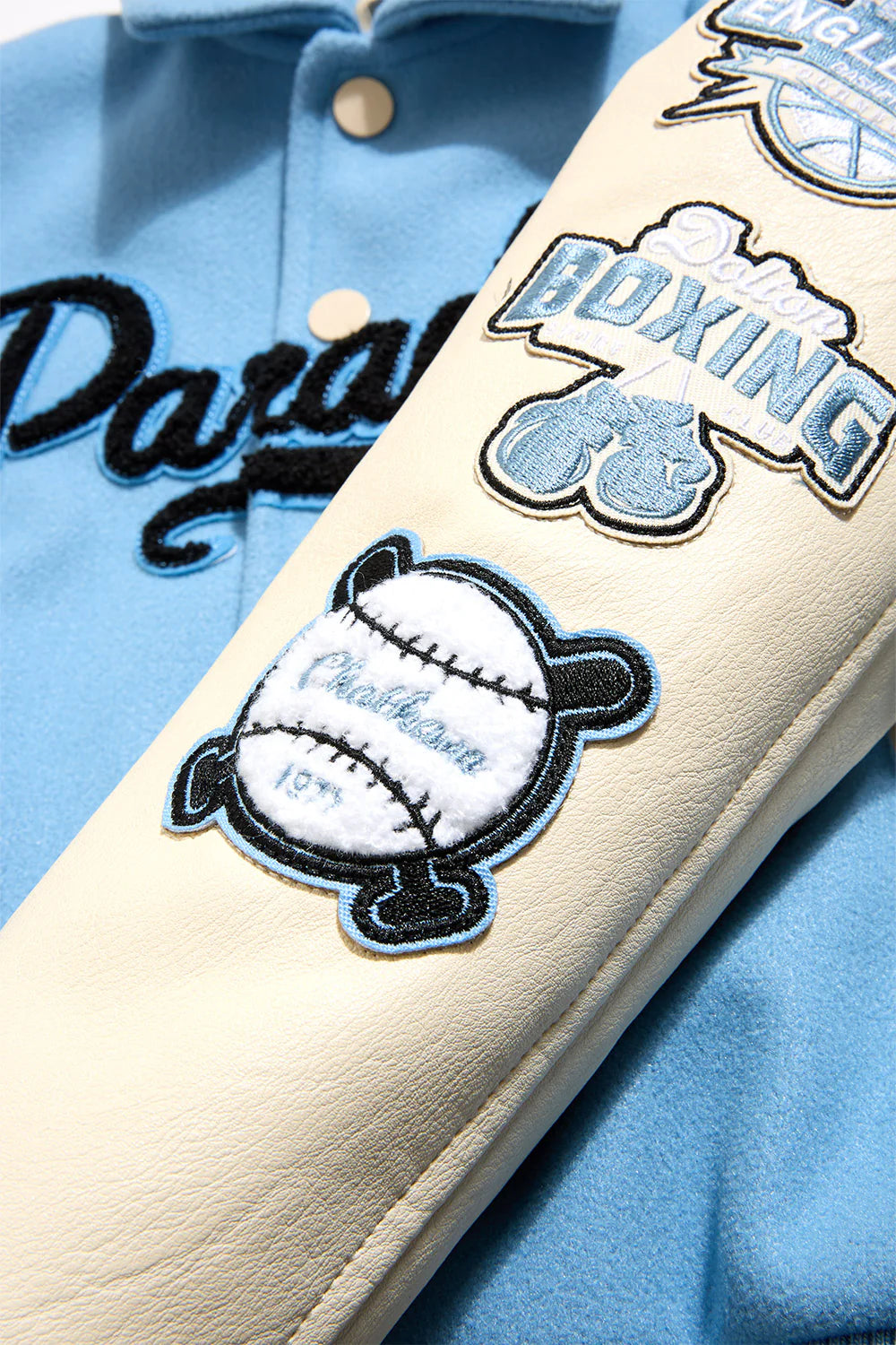 Paradise Team Varsity Jacket in Sky Blue with wool body, vegan leather sleeves, striped ribbed trims, and chenille patches