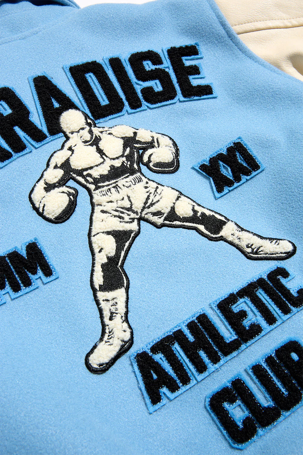 Paradise Team Varsity Jacket in Sky Blue with wool body, vegan leather sleeves, striped ribbed trims, and chenille patches