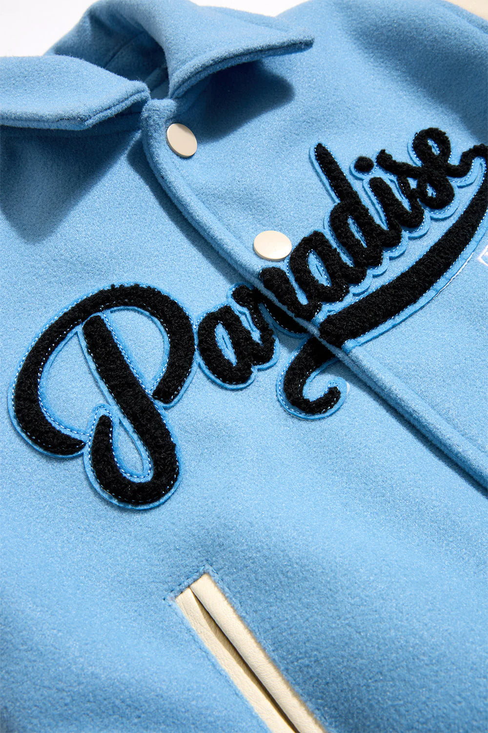 Paradise Team Varsity Jacket in Sky Blue with wool body, vegan leather sleeves, striped ribbed trims, and chenille patches