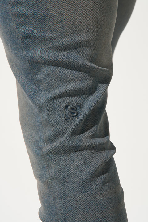 SERENEDE® ABYSS faded grey and muted blue wash jeans with fitted construction, embroidered logo, leather waistband patch, branded hardware, and five-pocket styling
