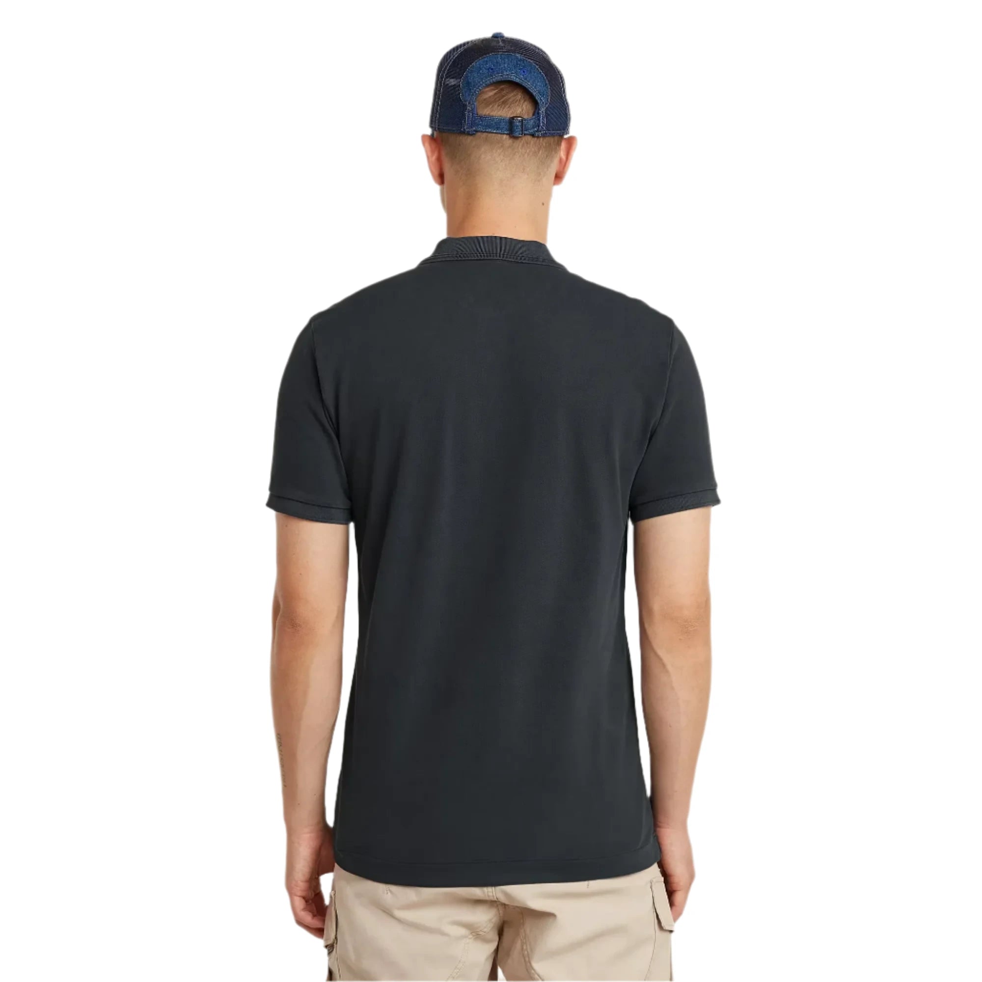 Man wearing a black polo shirt and blue cap from behind on a light gray background