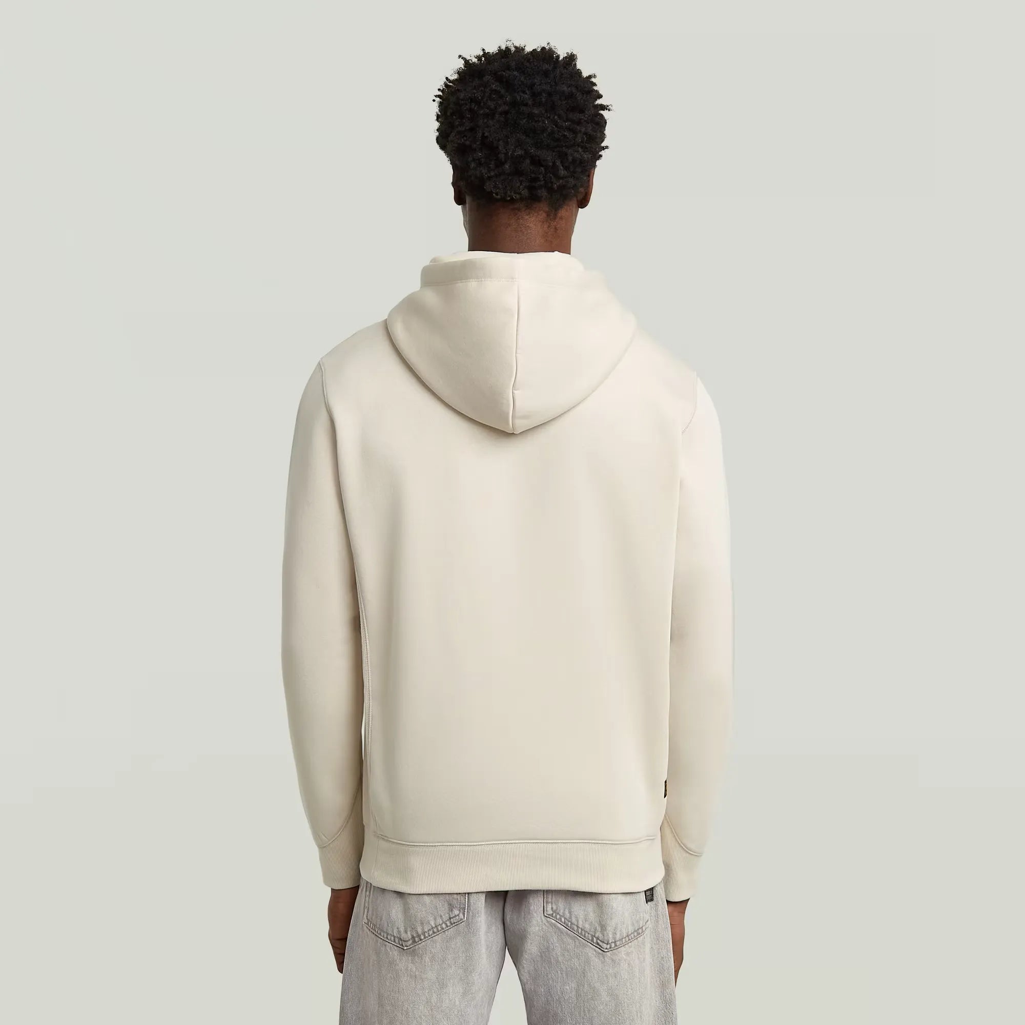 The Premium Core Hooded Sweater is a versatile essential designed with modern detailing and sustainable craftsmanship. Cut in a straight fit, it features a cross-over hood with drawstrings, a ribbed inset piece at the front, and a spacious kangaroo pocket for everyday utility. Ribbed side panels, cuffs, and hem ensure comfort and shape retention, while the chest is subtly finished with the iconic G-Star RAW embroidery.