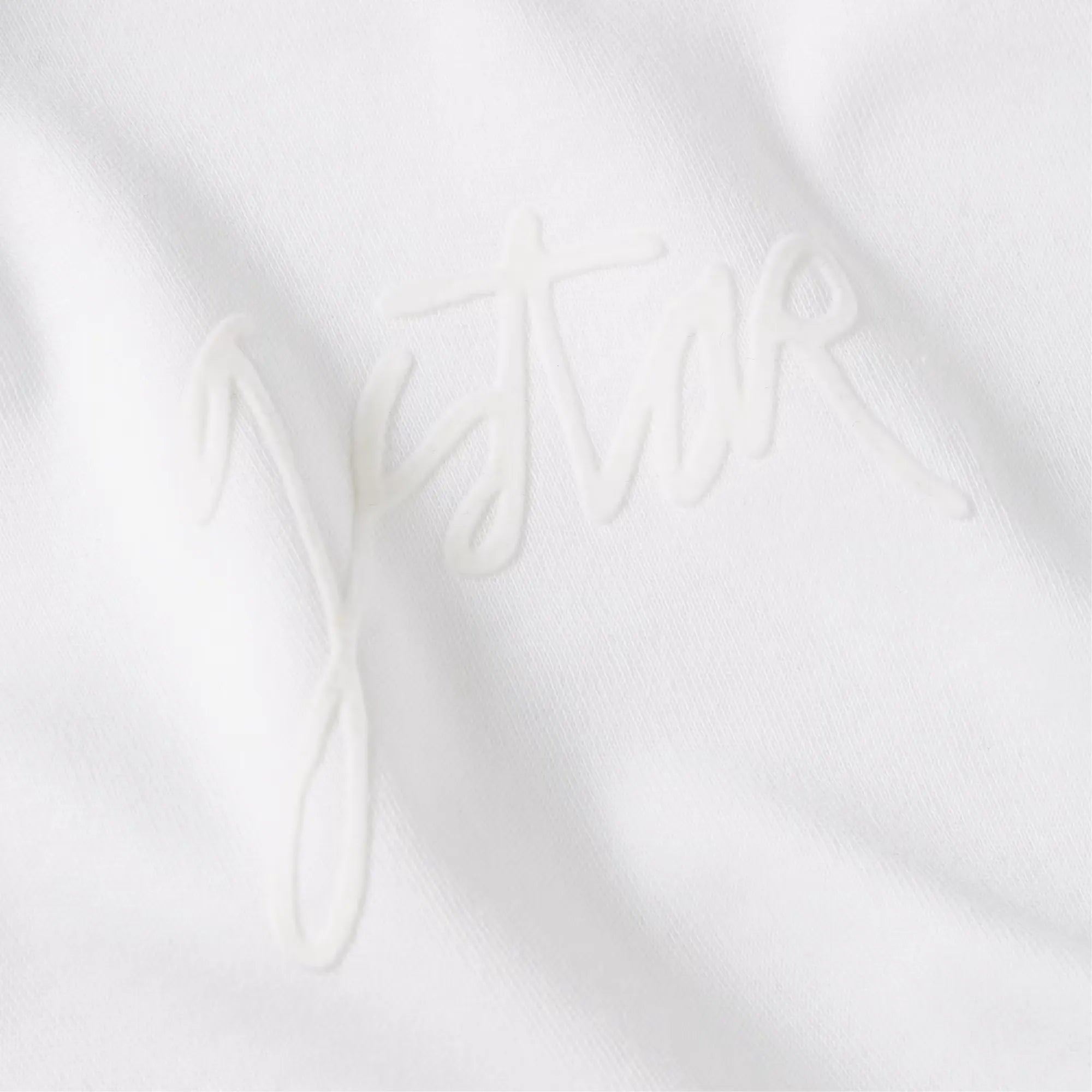 White fabric with 'GSTAR' embroidery on a white background