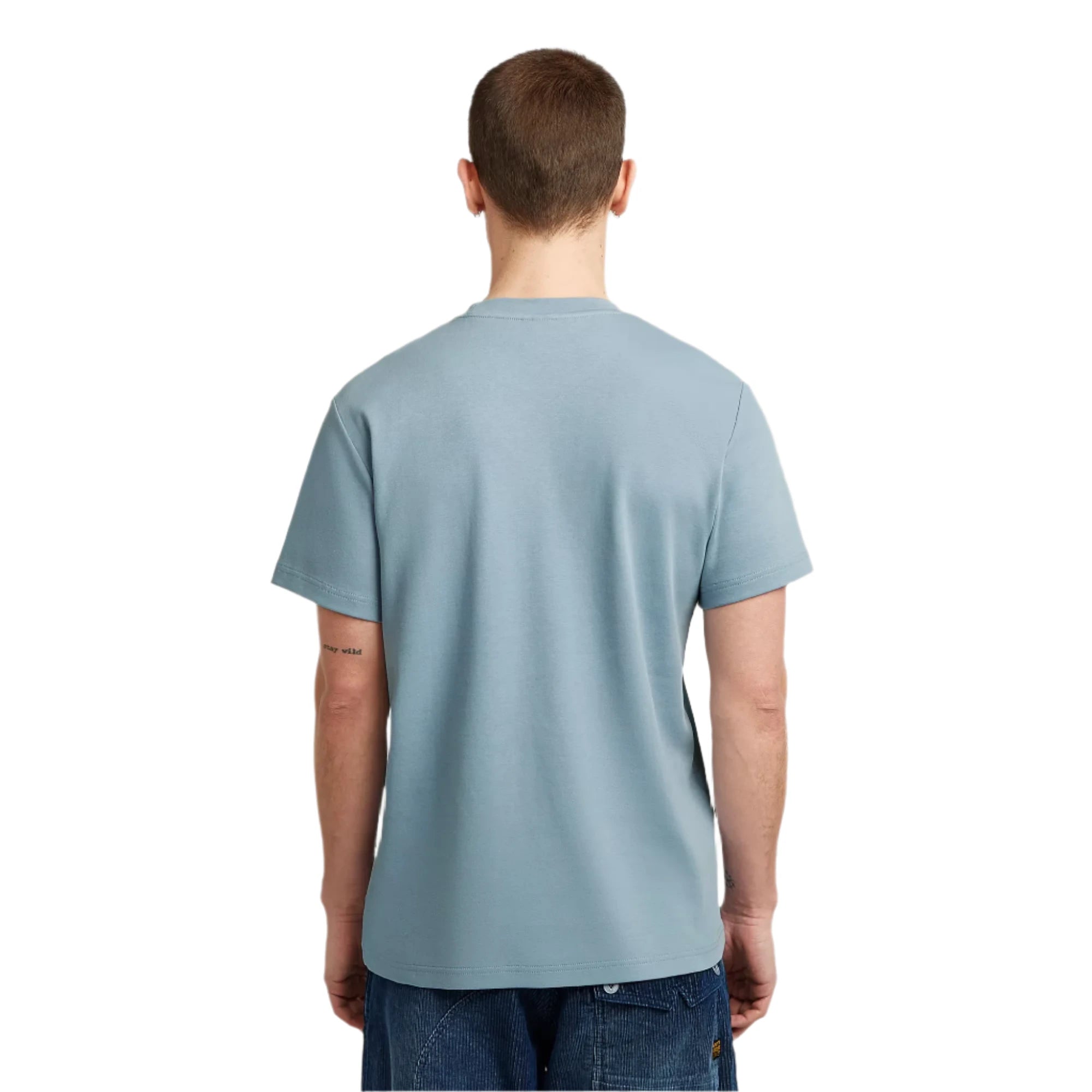 Person wearing a light blue t-shirt on a plain background