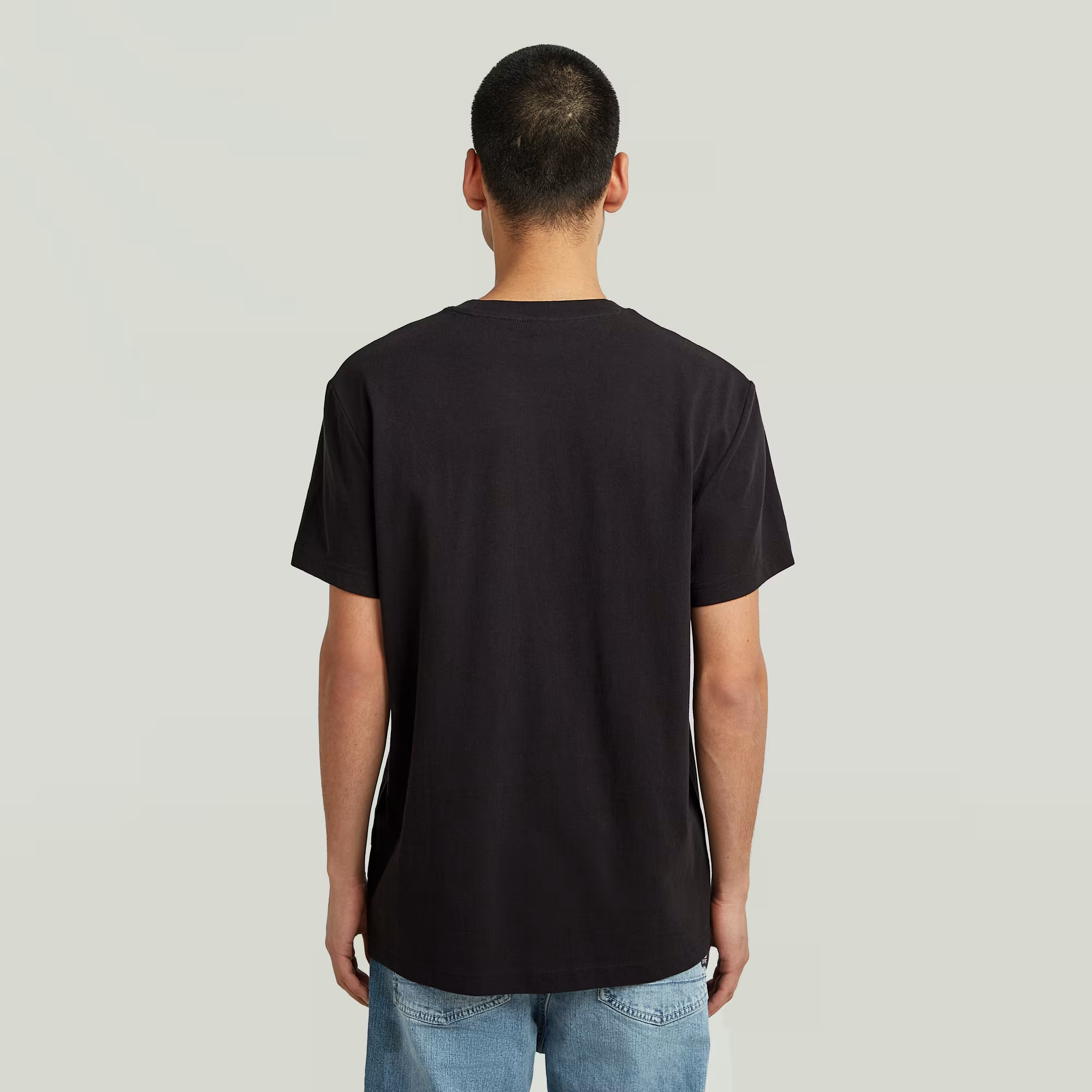 Person wearing a black t-shirt on a plain background
