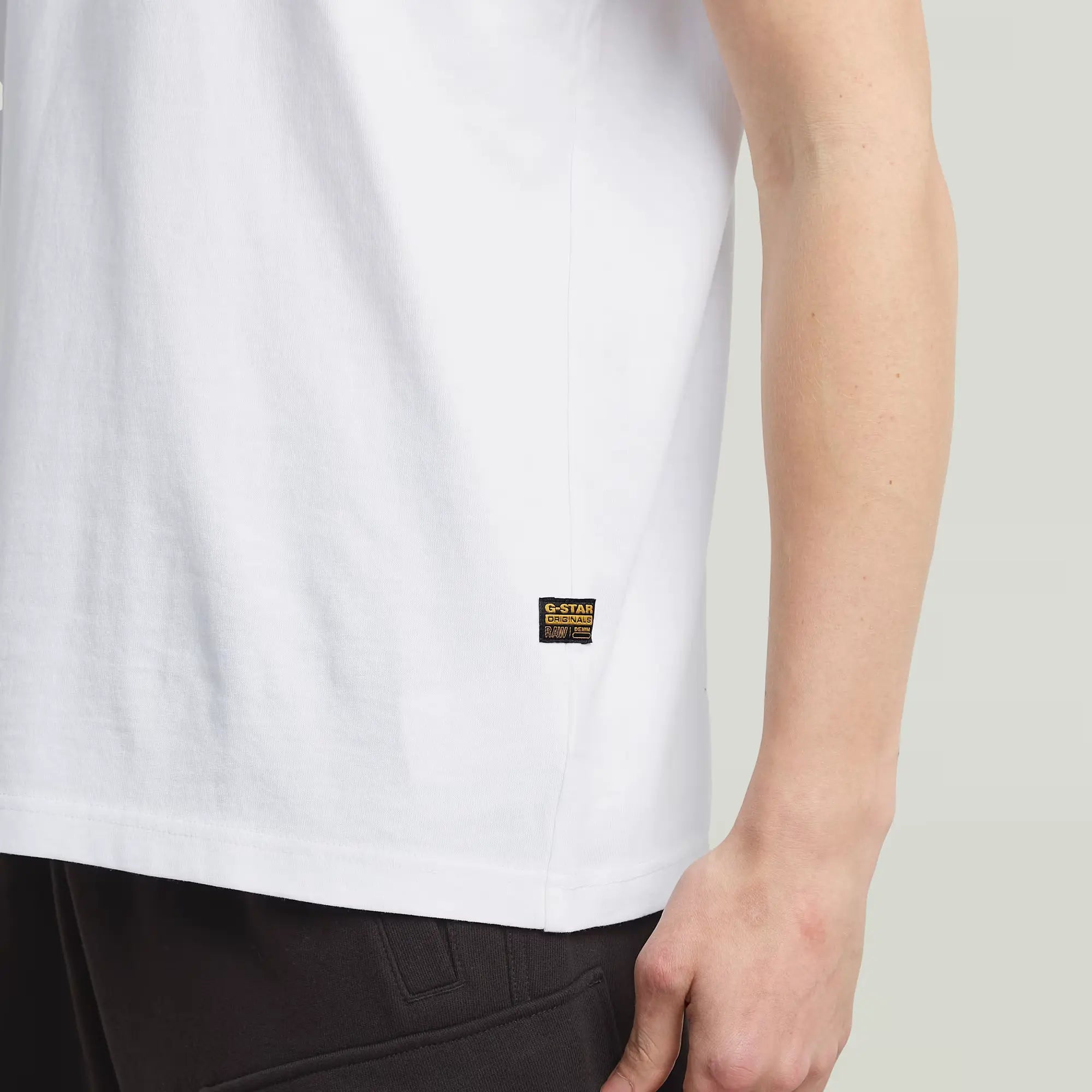 White t-shirt with a brand logo on a plain background