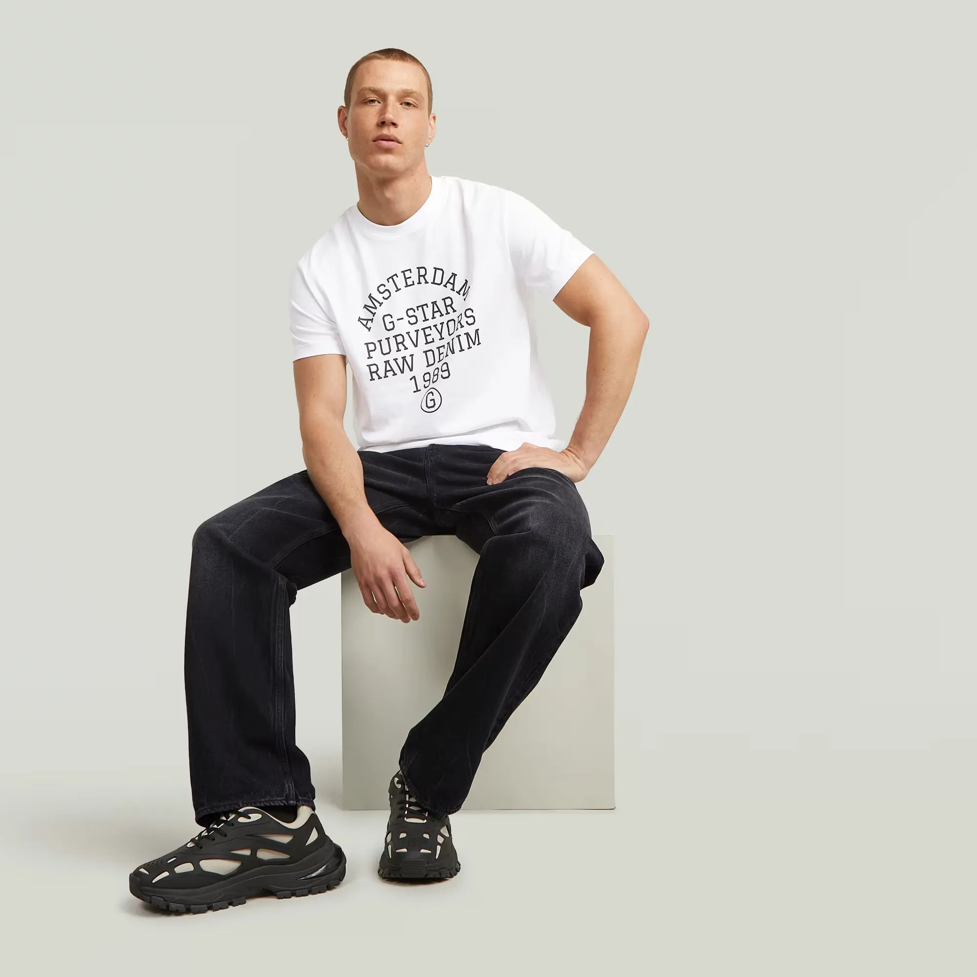 Purveyors T-shirt in white with a round neck and graphic print on the front.