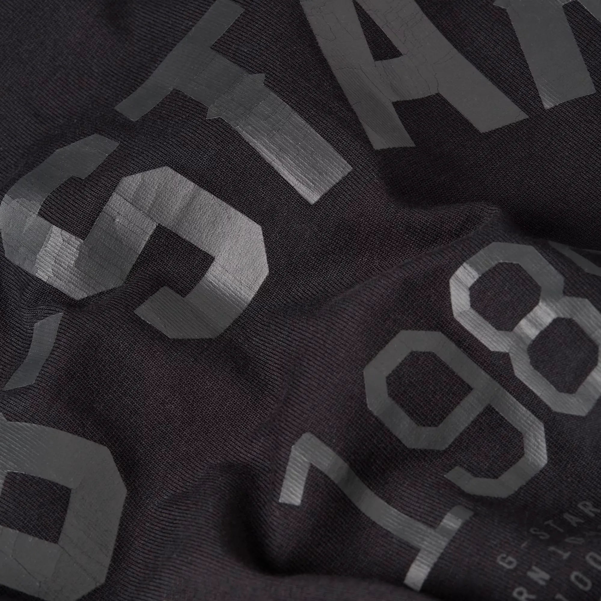 89 Back Graphic Loose T-shirt in dark black with graphic prints on the front and back.