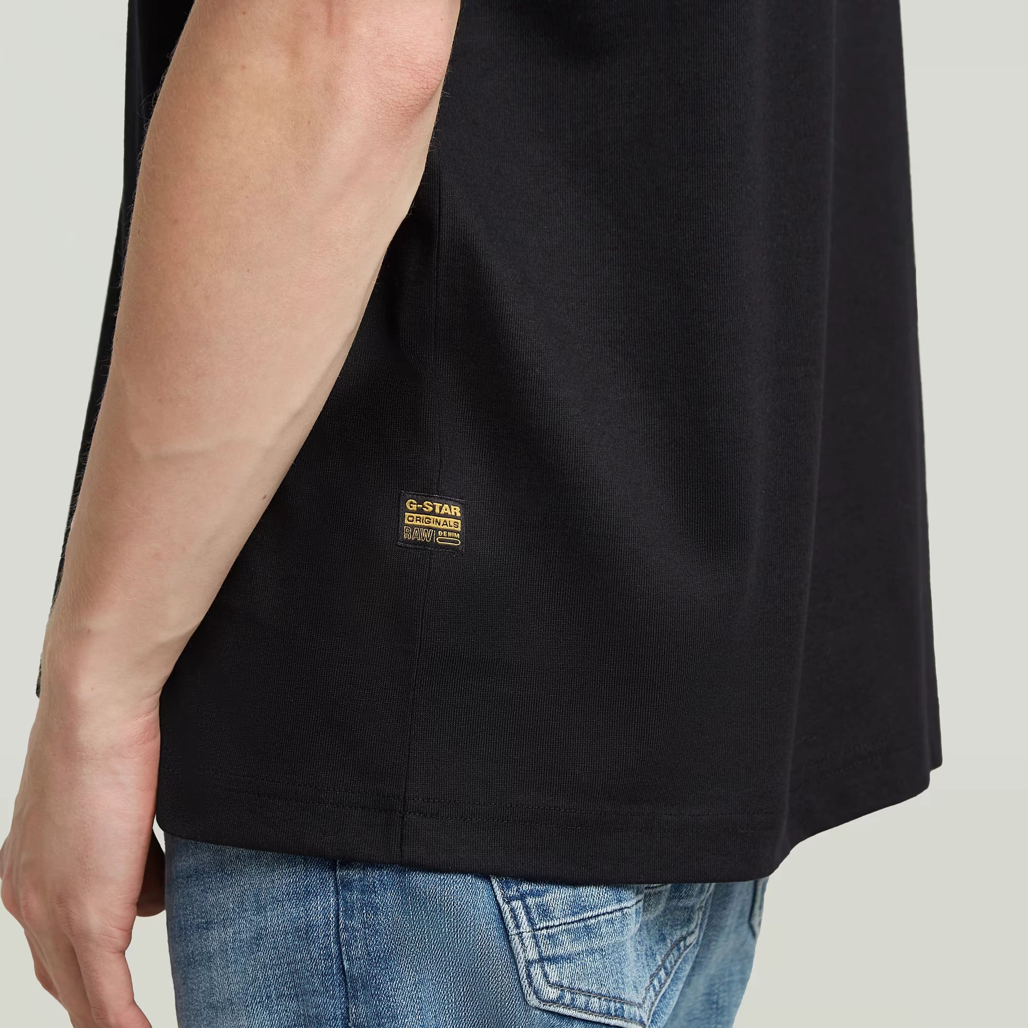 Black sleeveless shirt with a brand logo on a plain background