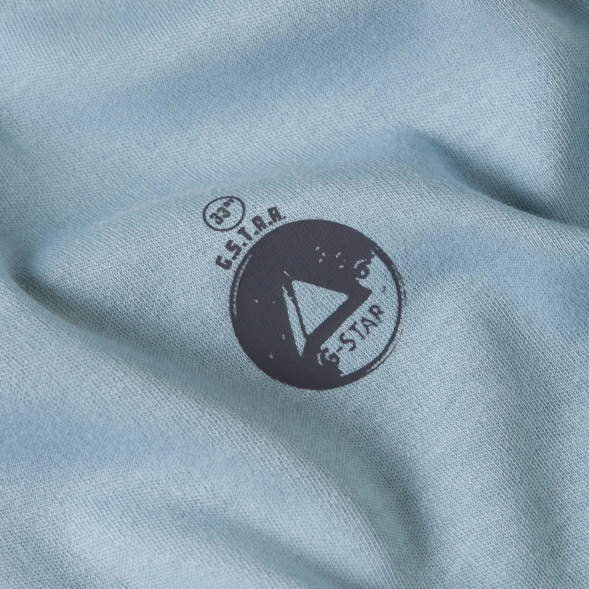 G-Star logo on a light blue fabric background