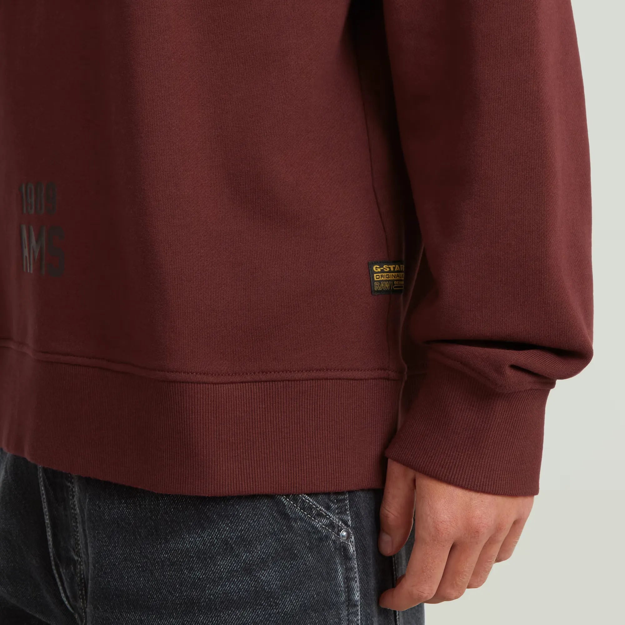 Applique sweater in port red with a round neck and graphic design.