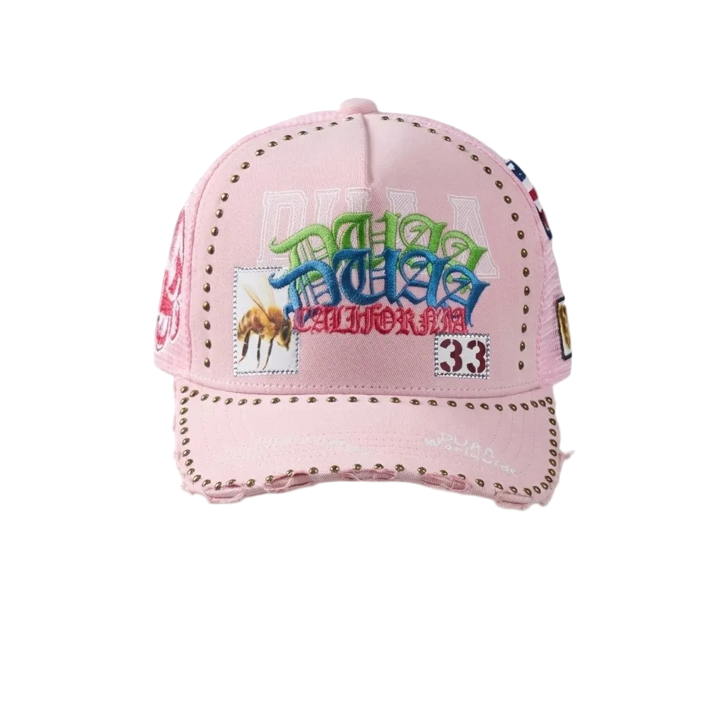 DUAA Air Hat featuring pink front panel, mesh back, multicolor graffiti embroidery, bee and 33 patch details, gold stud trim, and distressed brim snapback design.
