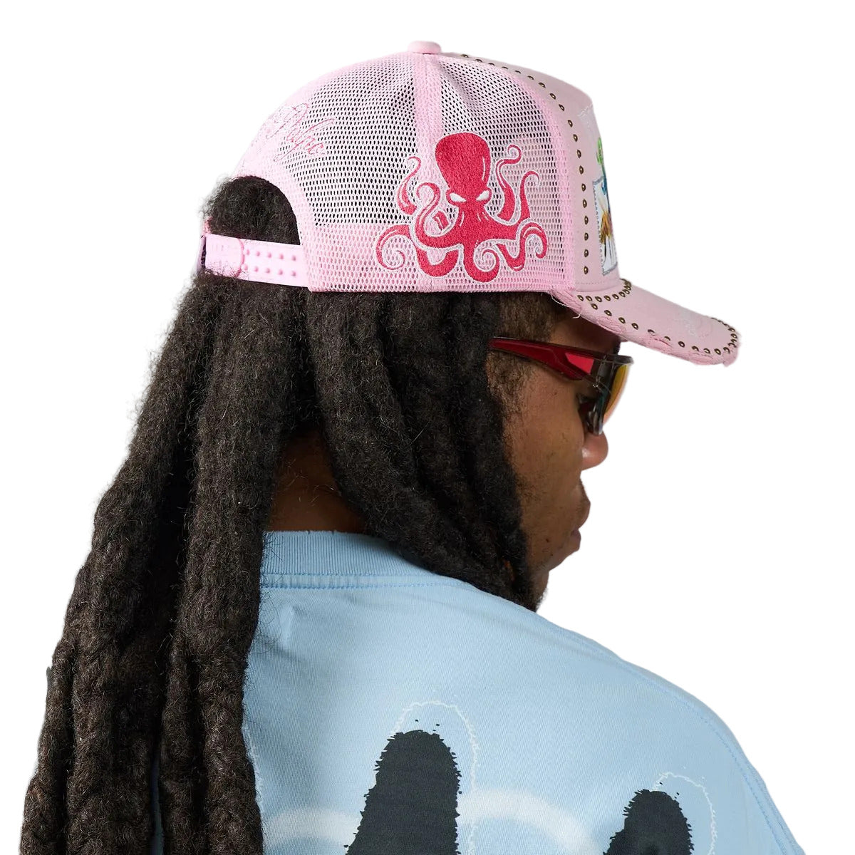 DUAA Air Hat featuring pink front panel, mesh back, multicolor graffiti embroidery, bee and 33 patch details, gold stud trim, and distressed brim snapback design.