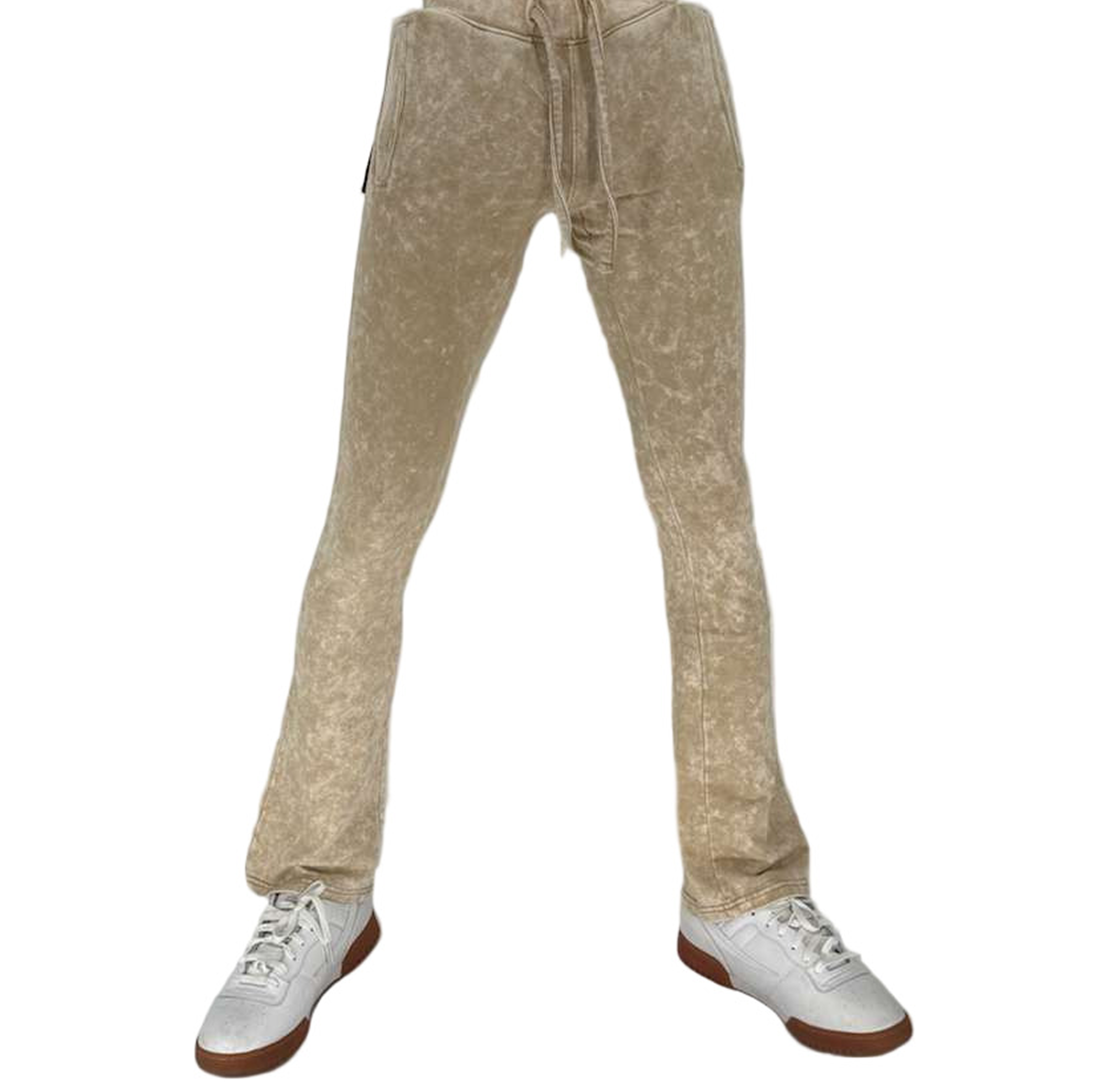 Beige sweatpants worn with white sneakers on a white background