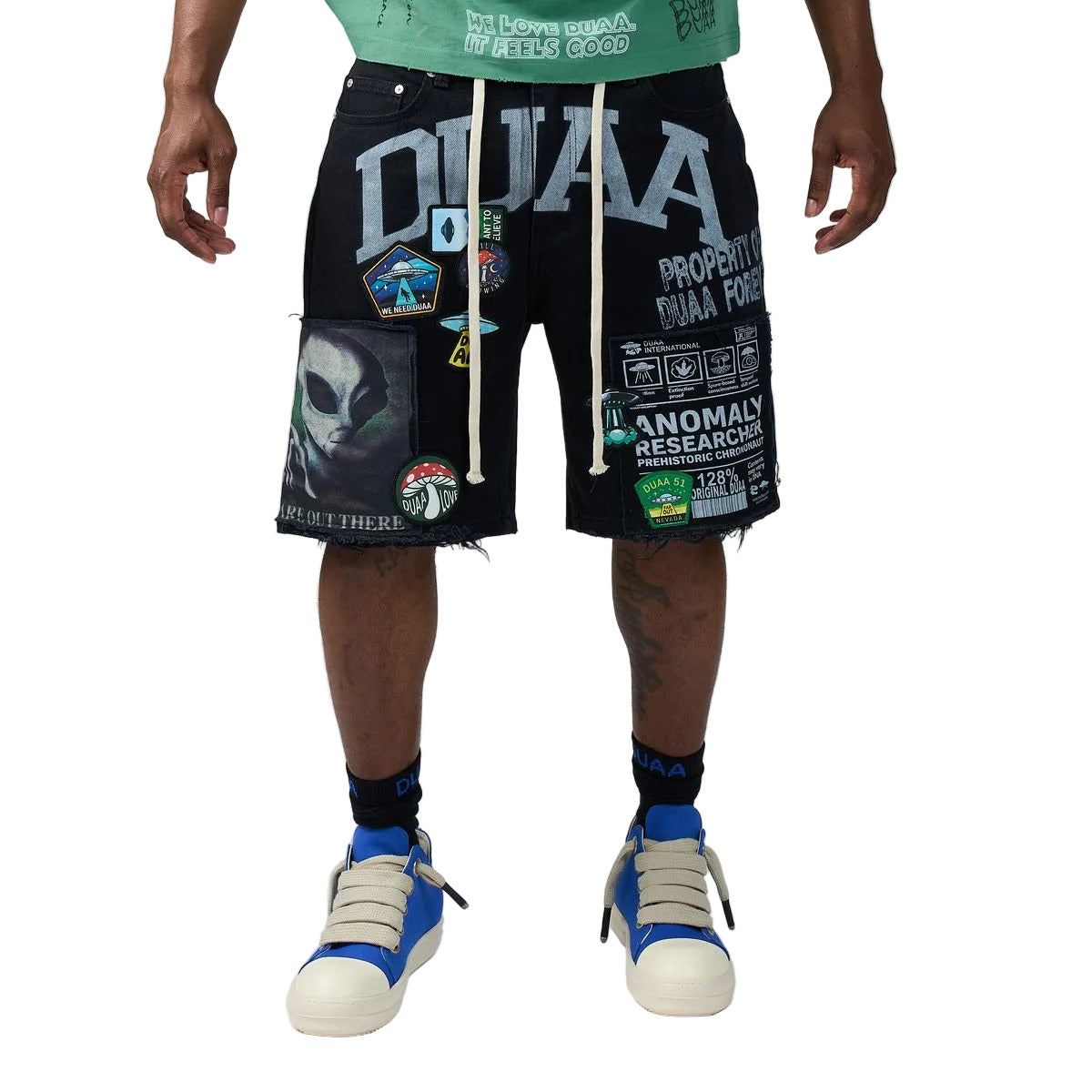 DUAA UFO Black denim shorts in a black colorway featuring an alien and UFO collage print, collegiate DUAA lettering with rhinestones, embroidered patches, and a drawstring waist.