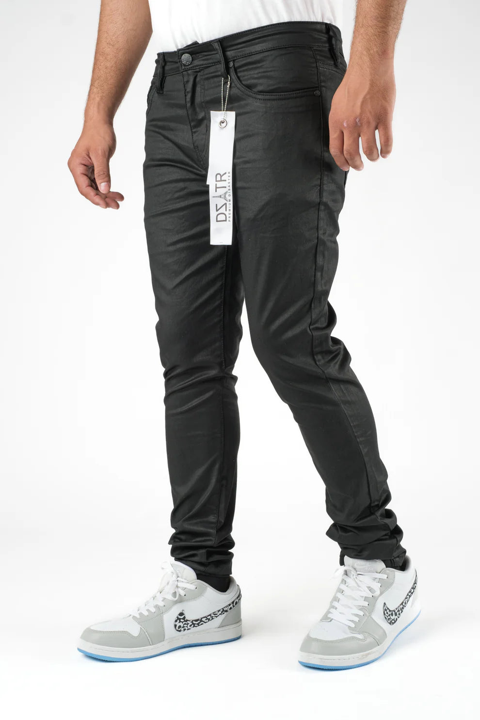 Person wearing black pants with a visible brand tag on a white background