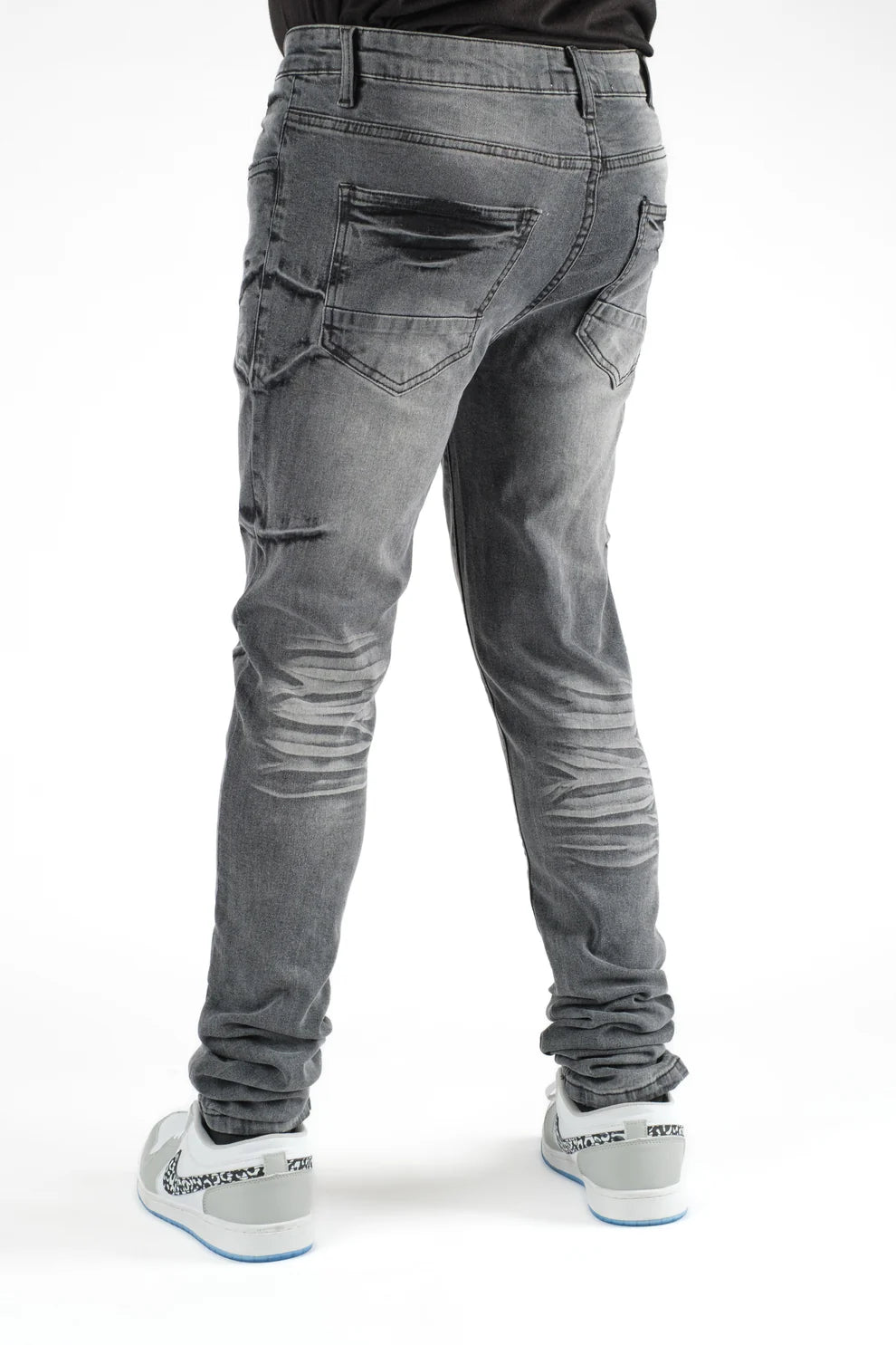 Gray jeans worn by a person on a white background