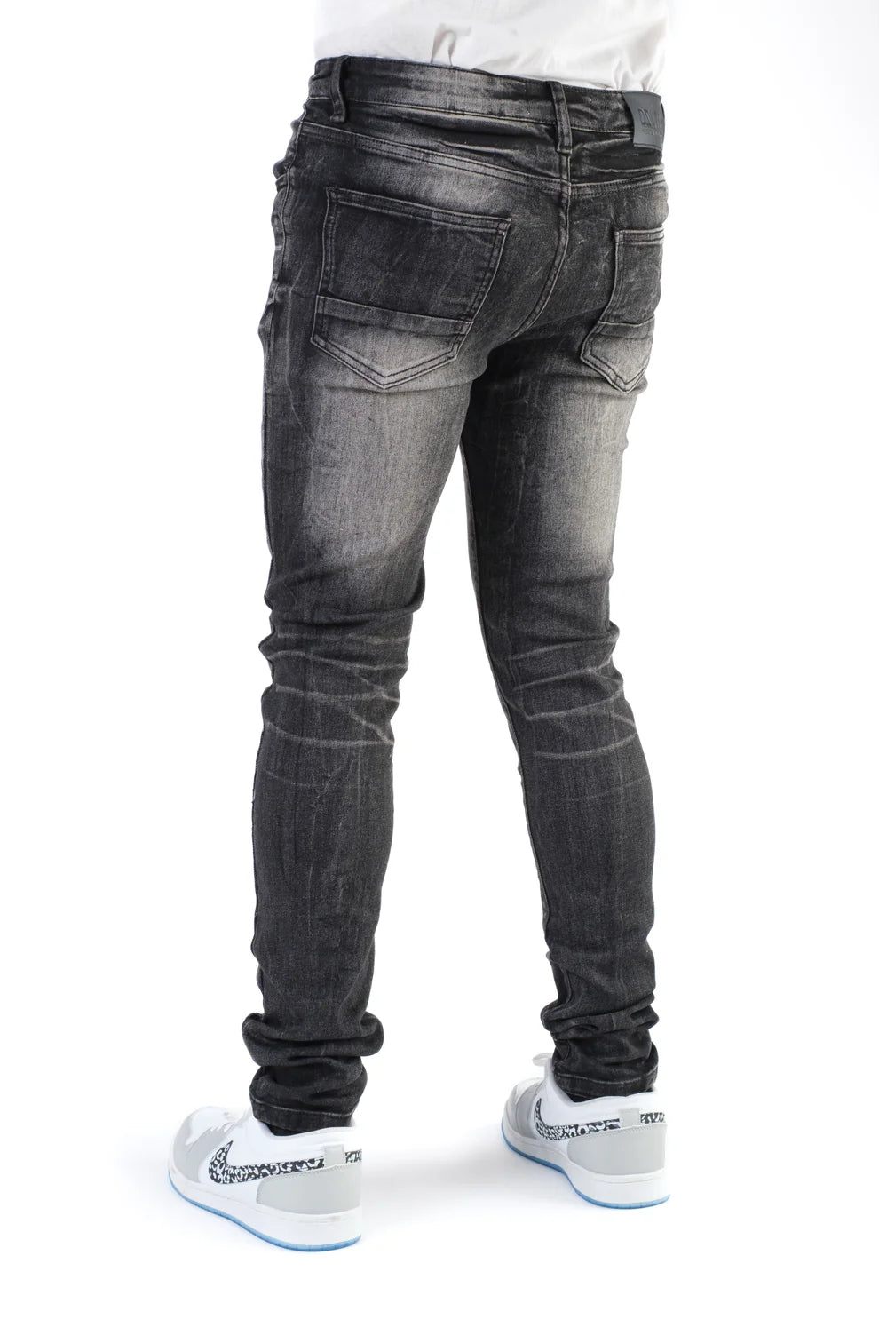 Person wearing black jeans on a white background