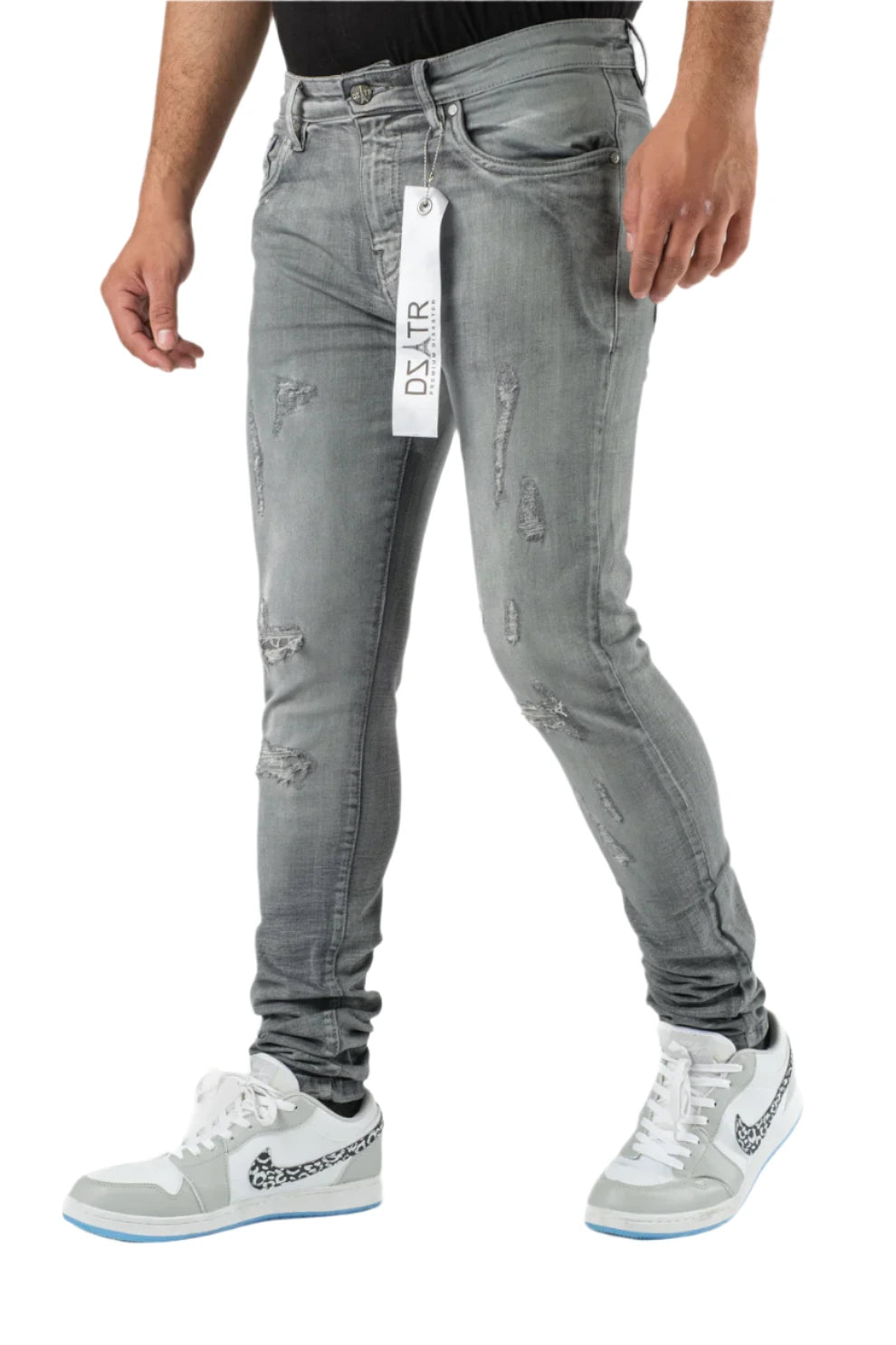Gray distressed jeans with a brand tag on a white background