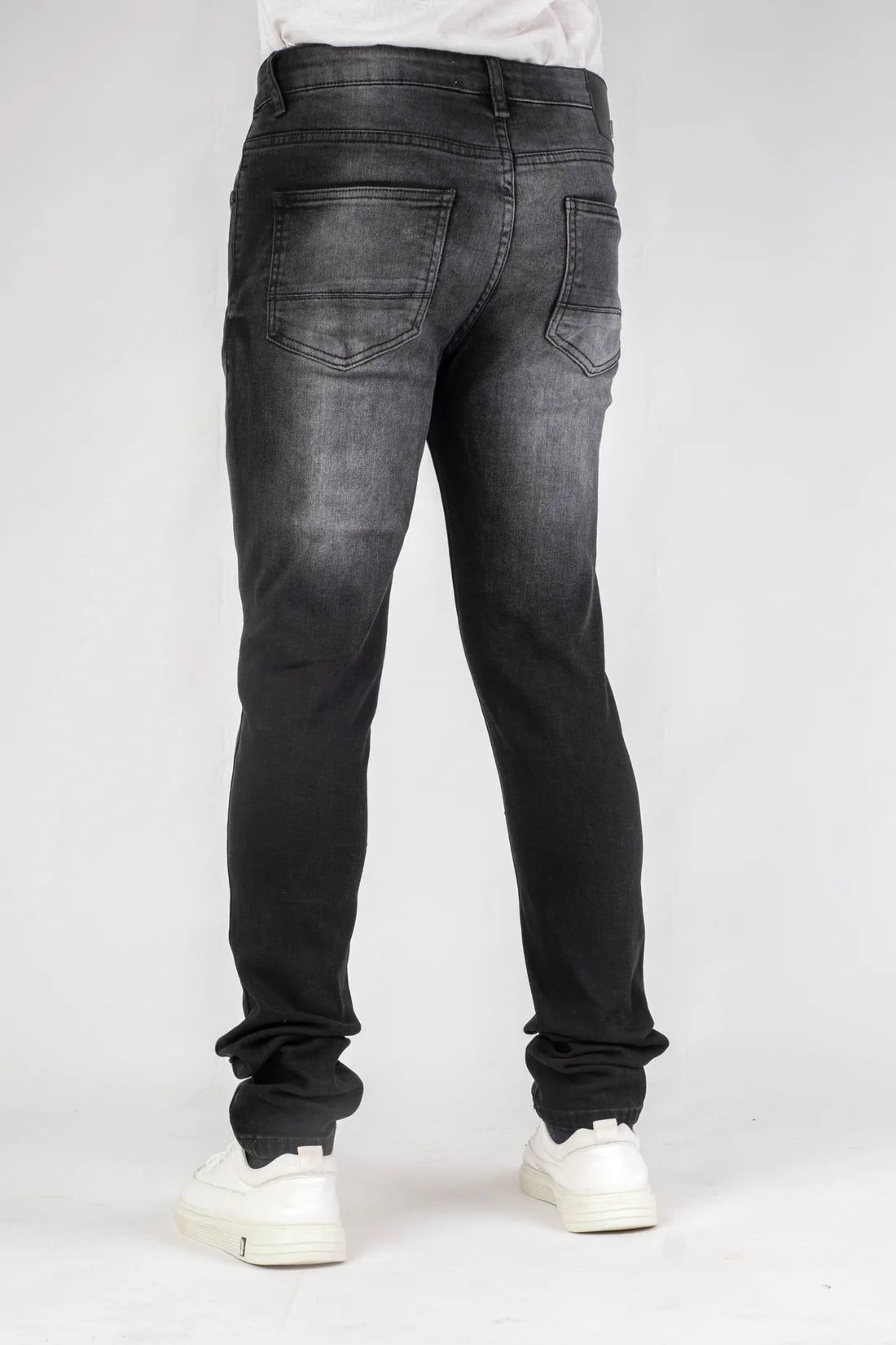 Black jeans worn by a person on a white background