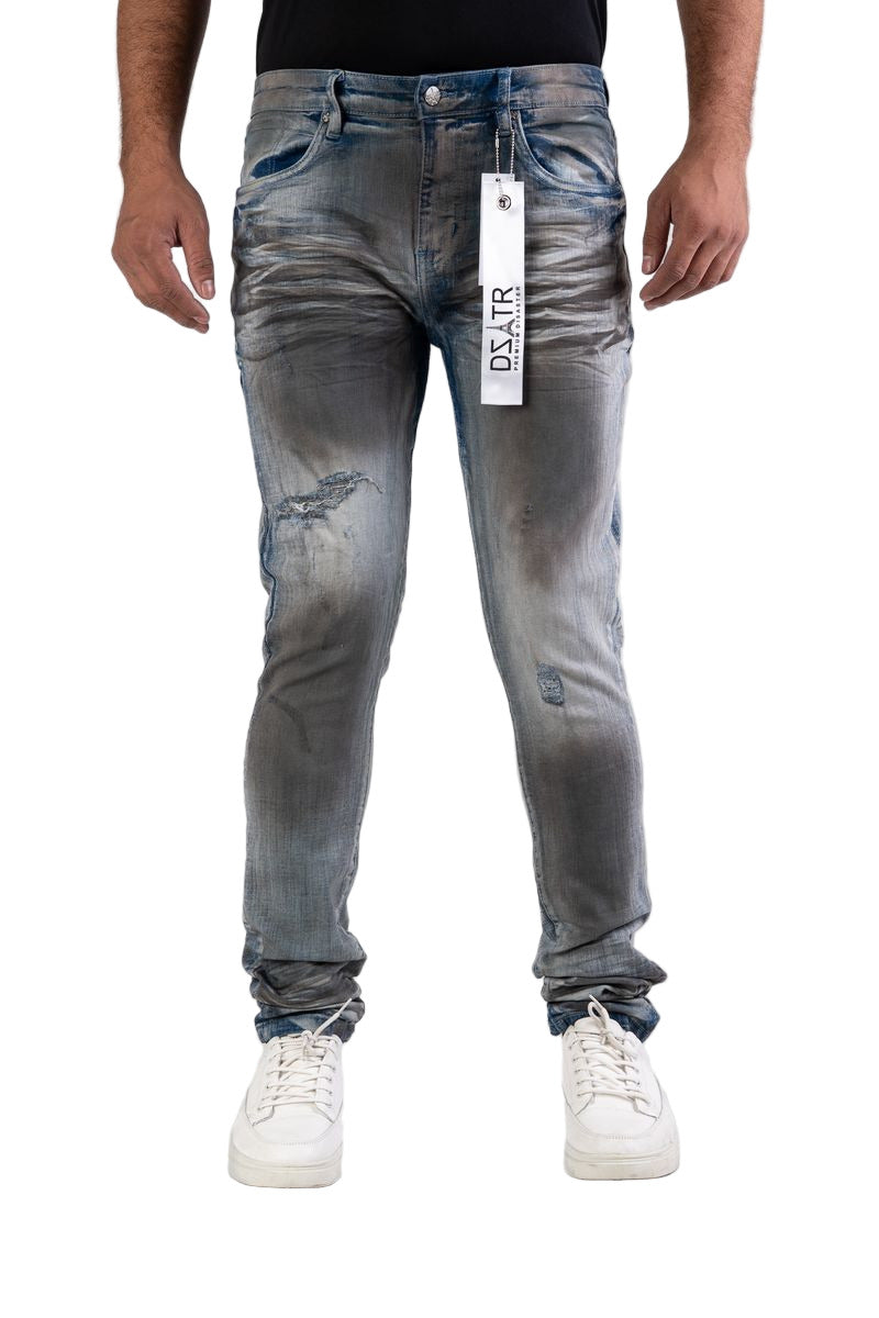 Person wearing distressed blue jeans with a visible brand label on a white background
