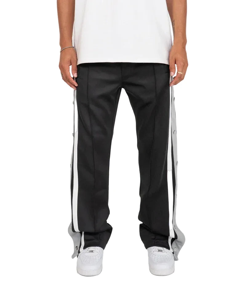 EPTM Gully Track Pants in black with side seam stripes, metal logo snap buttons, front pintucks, and relaxed flare fit