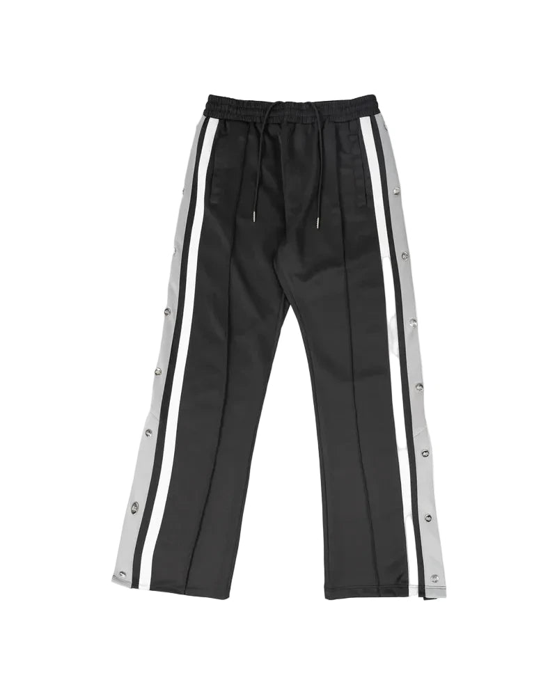 EPTM Gully Track Pants in black with side seam stripes, metal logo snap buttons, front pintucks, and relaxed flare fit