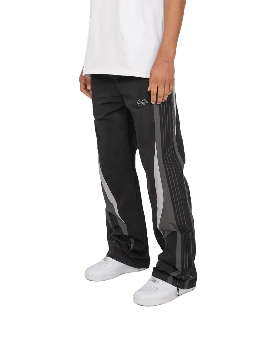 Baladin black pants with bold color blocking, tonal tape details, elastic waistband with adjustable cord and toggles, and front and back pockets