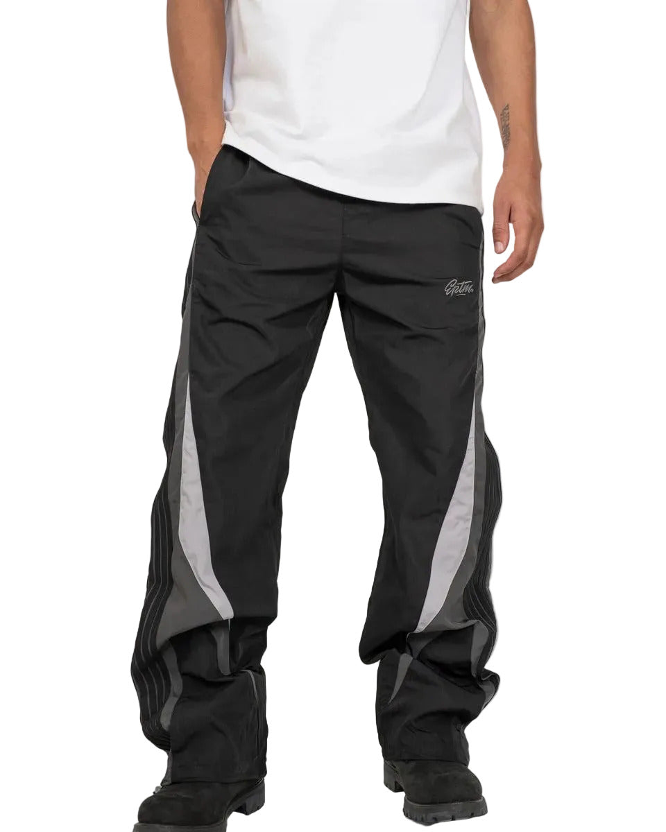 Baladin black pants with bold color blocking, tonal tape details, elastic waistband with adjustable cord and toggles, and front and back pockets