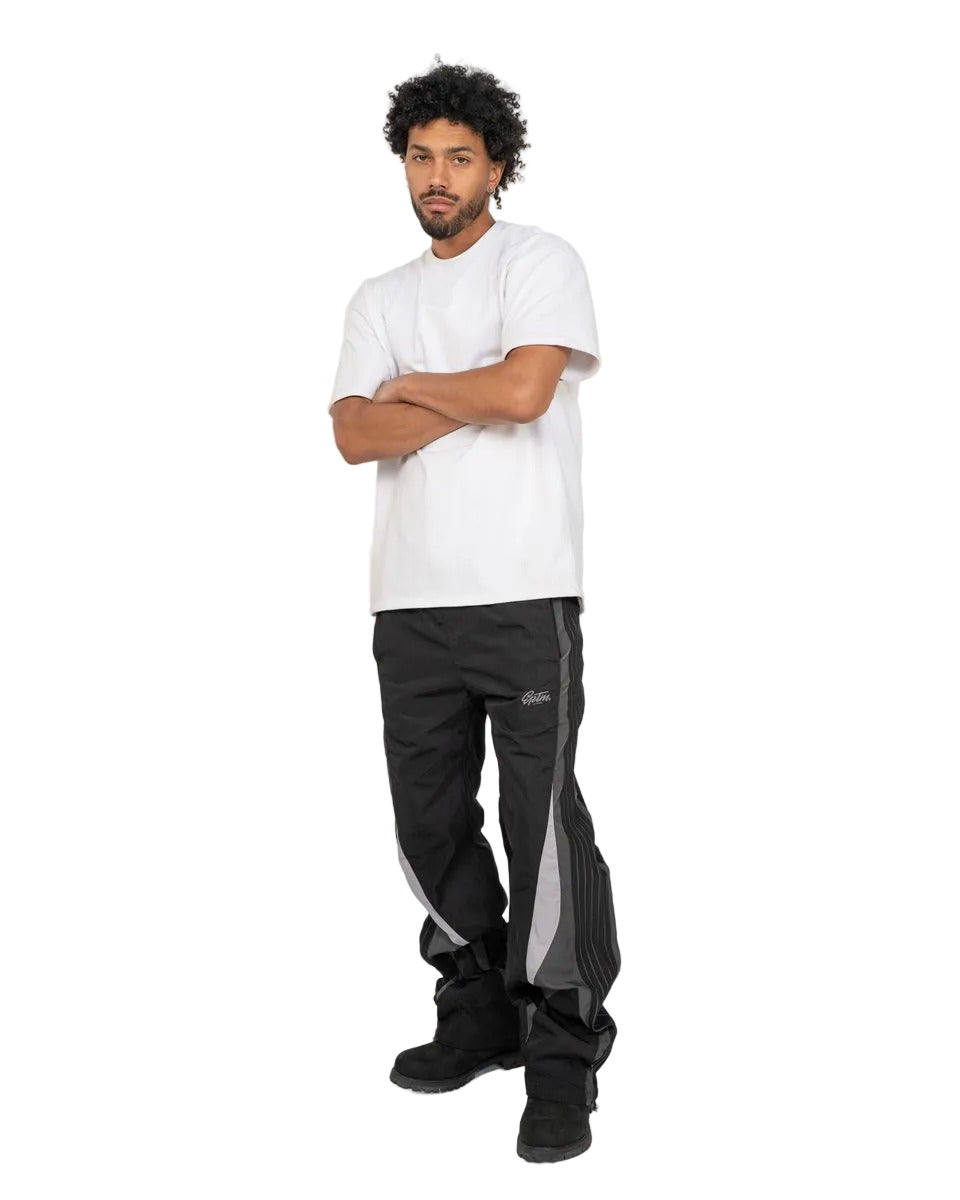 Baladin black pants with bold color blocking, tonal tape details, elastic waistband with adjustable cord and toggles, and front and back pockets
