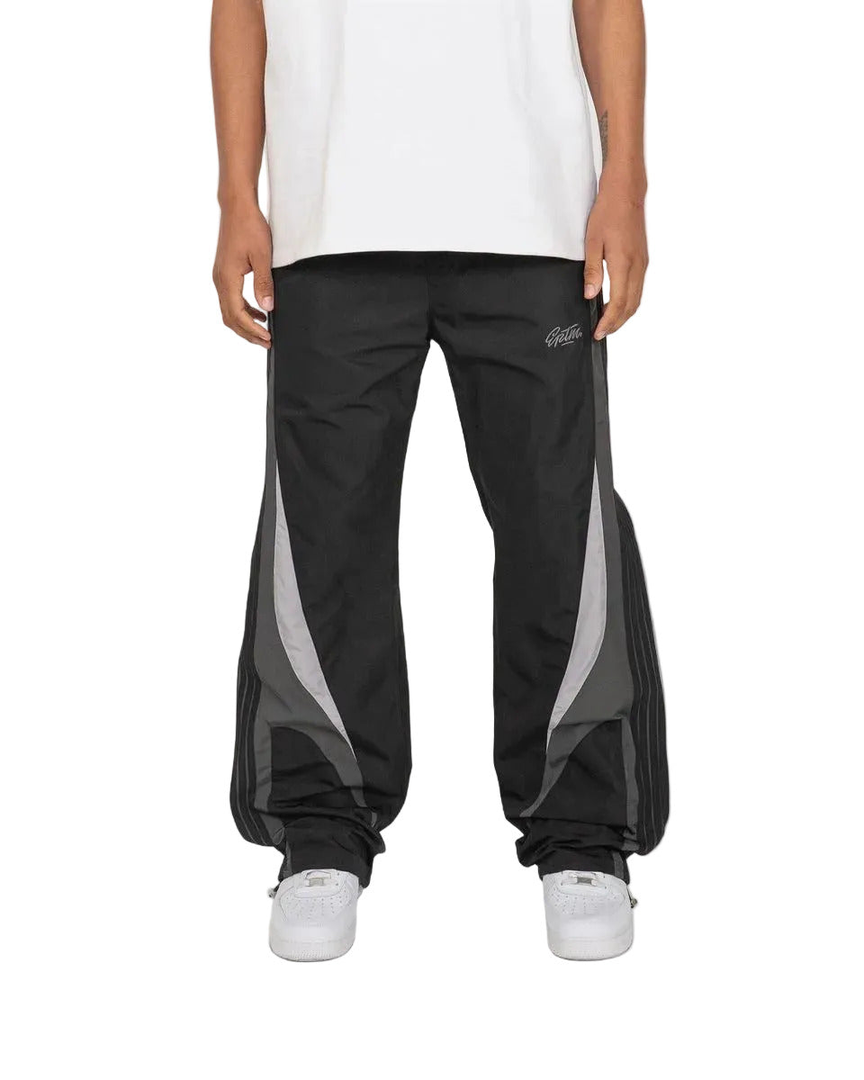 Baladin black pants with bold color blocking, tonal tape details, elastic waistband with adjustable cord and toggles, and front and back pockets