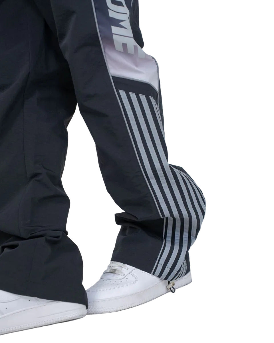 Eclipse pants with ripstop nylon construction, ombre panels, reflective 3M accents, elastic waistband with drawstring, and adjustable bottom toggles