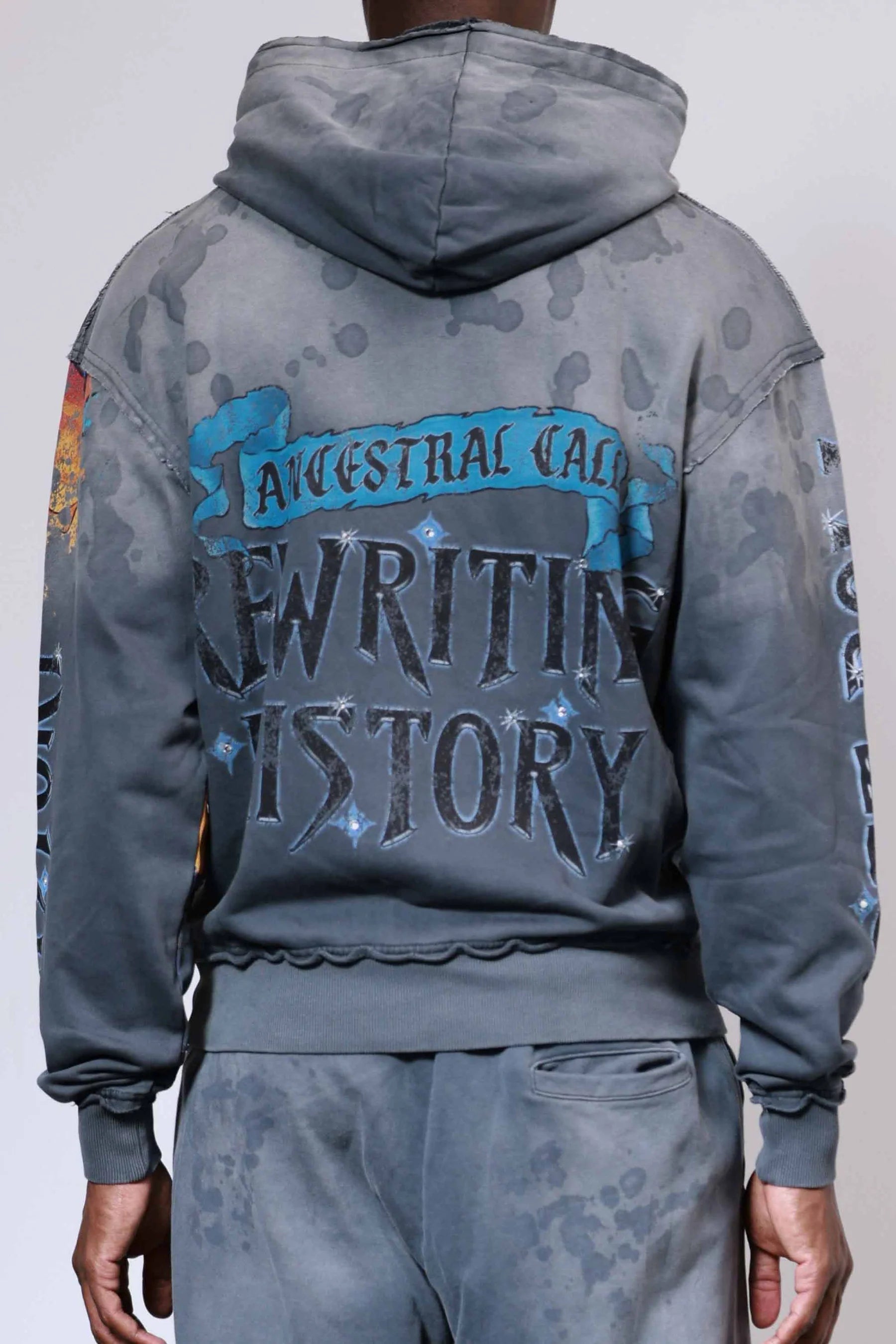 Firstrow ANCESTRAL CALL SPIRIT WALKER Hoodie in heavy washed fabric with rhinestones, oversized fit, raw edge hem, and kanga pocket.