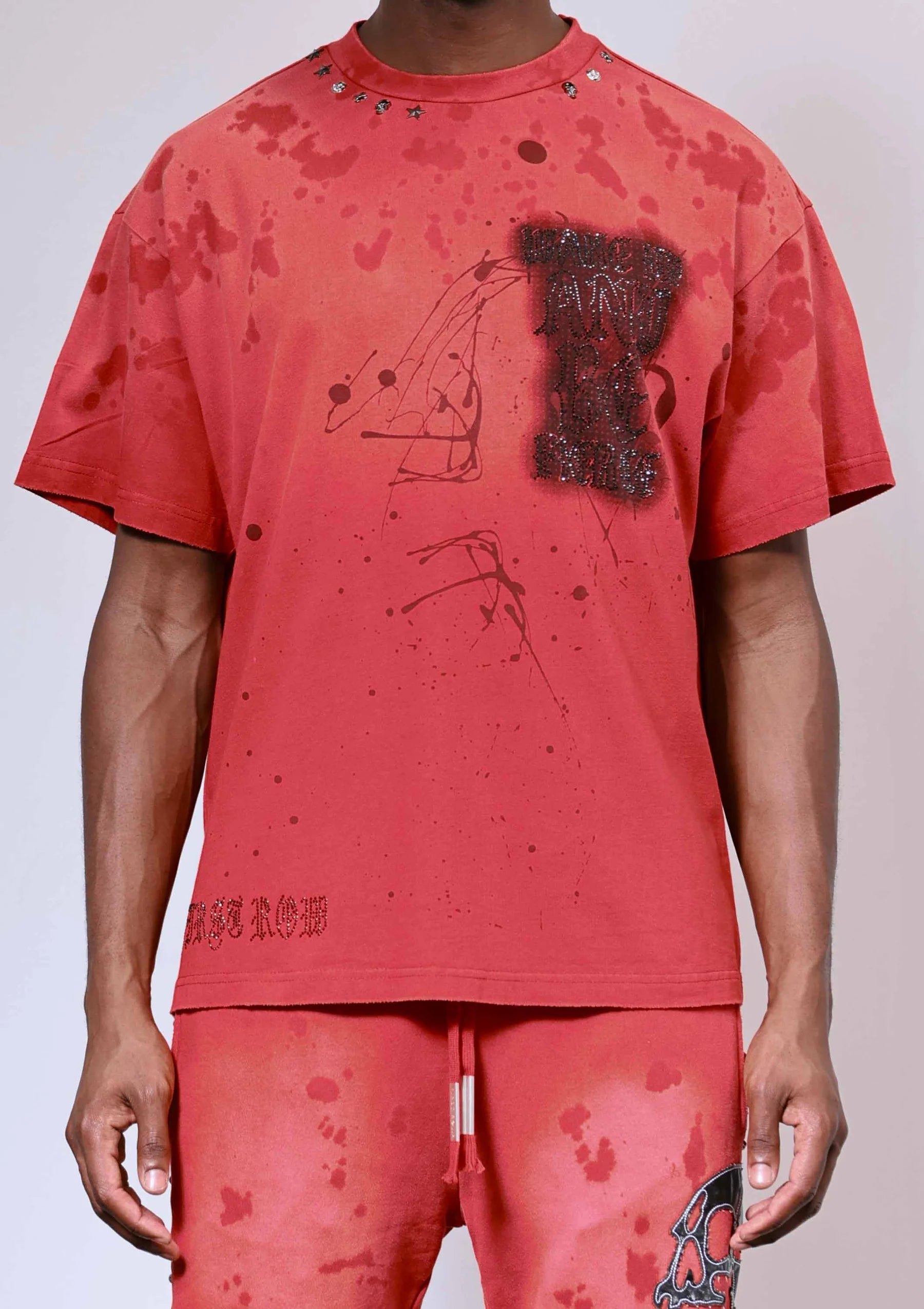 "First Row Wake Up And Be Fierce Applique Tee in red with applique embroidery, stud accents, and bleach splash wash effect."