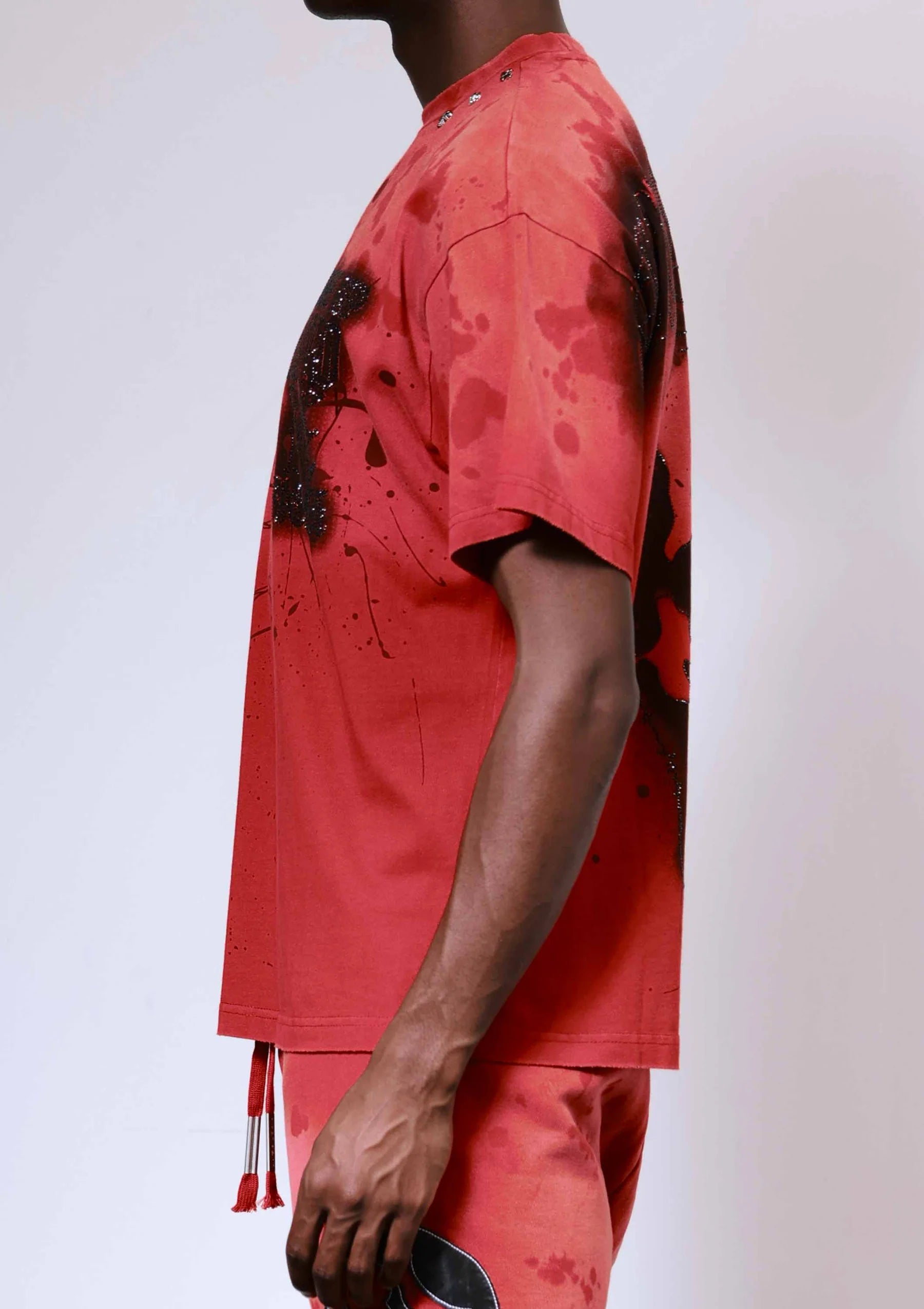 "First Row Wake Up And Be Fierce Applique Tee in red with applique embroidery, stud accents, and bleach splash wash effect."