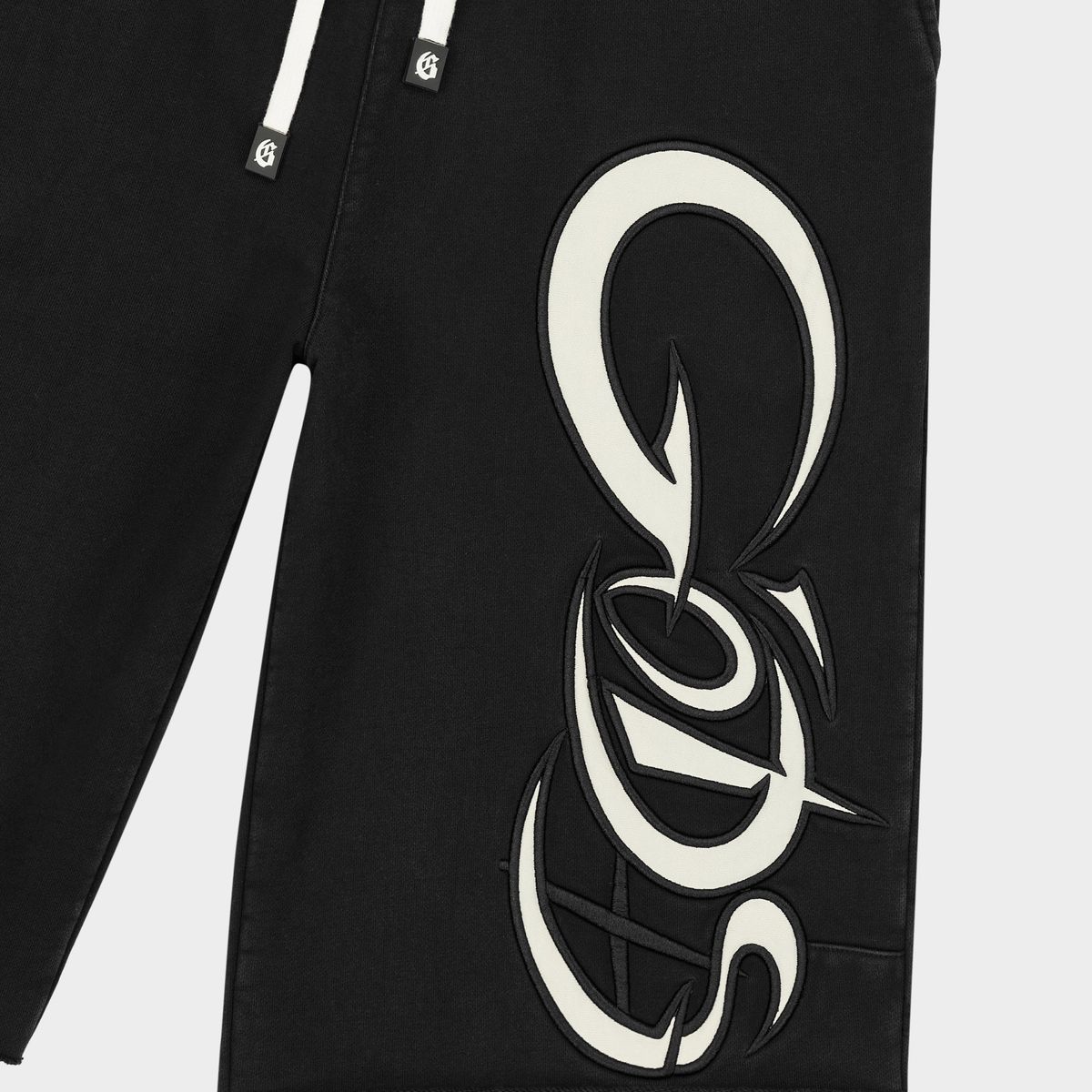 Godspeed New Age 3QTR shorts in black featuring heavyweight French terry cotton, oversized side graphics, racing-inspired piping, and a relaxed extended-length fit.