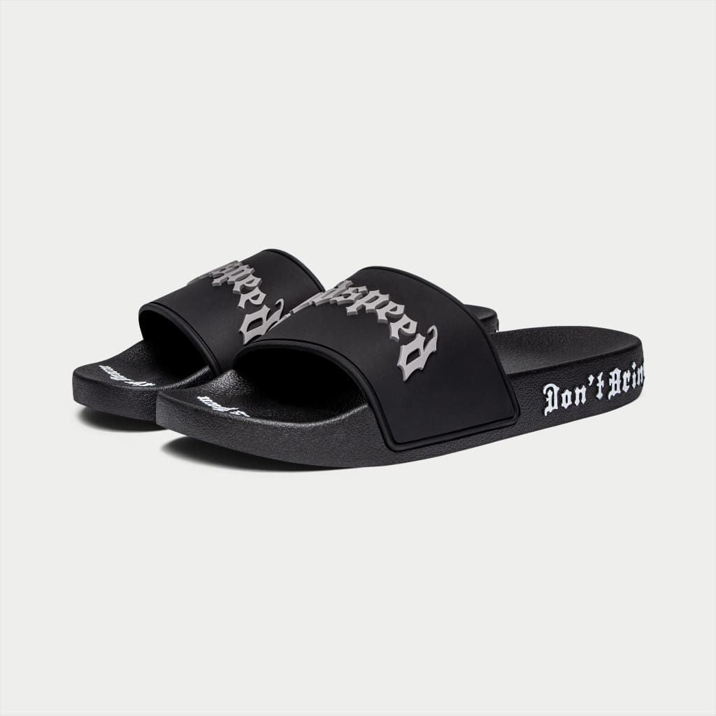 Black Godspeed OG Logo Slides featuring “DON’T BRING SAND TO THE BEACH” tagline with branded box and dust bag.