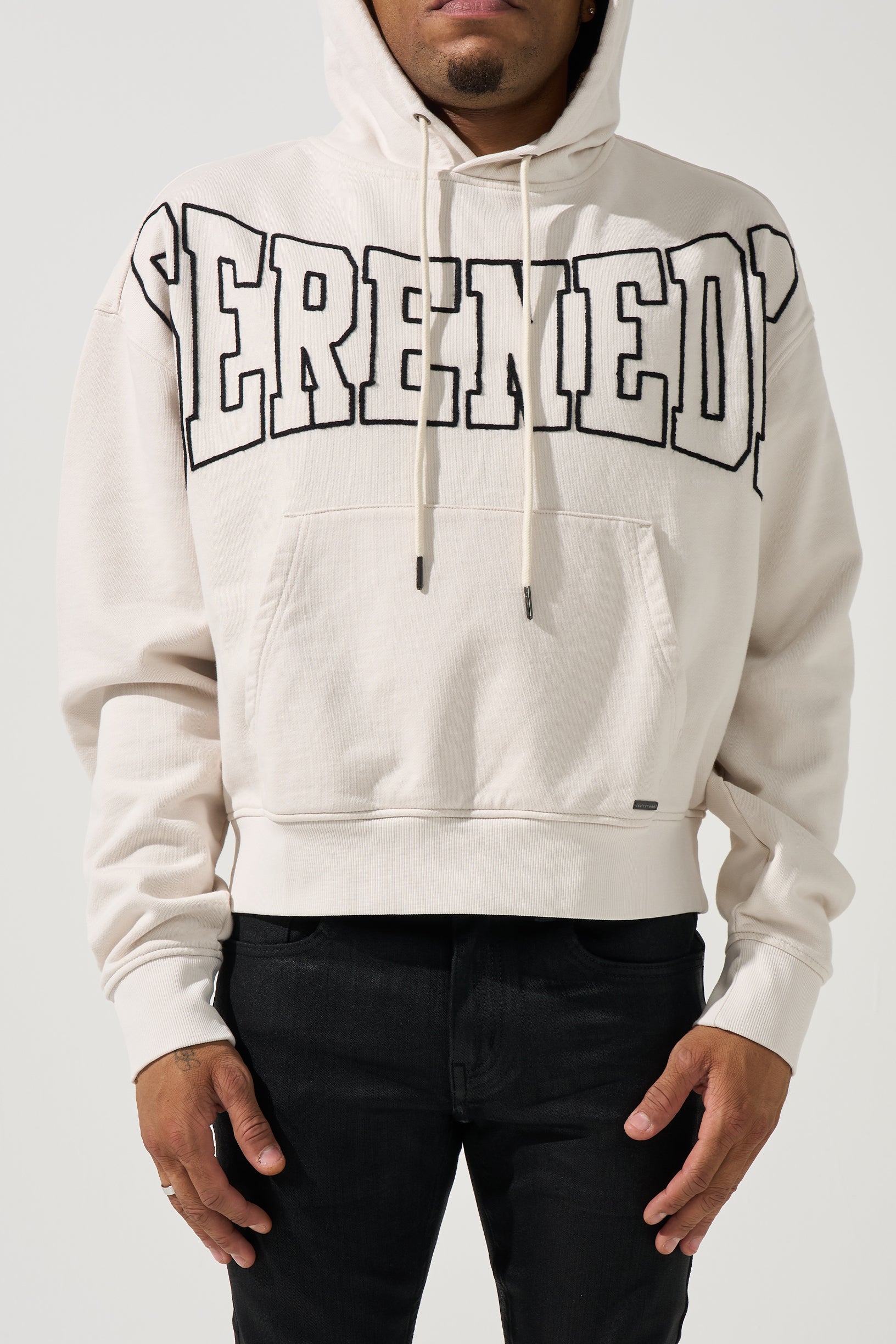 SERENEDE® LEGACY Ivory Hoodie with black outlined chest branding, kangaroo pocket, and relaxed fit.