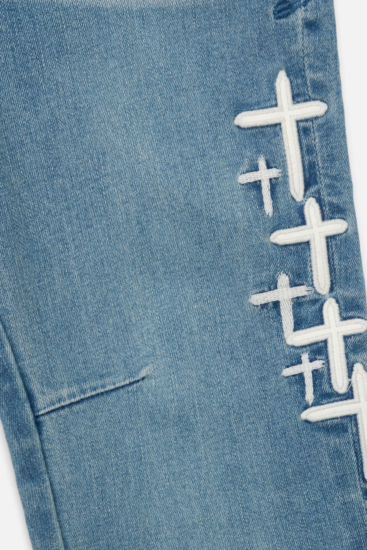 RtA Benson skinny jeans in Coastal Drift with embroidered cross patches and RtA logo on the back pocket.