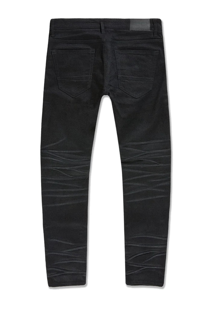 Dyckman straight fit denim jeans in polished black with glossy coated finish and rip-and-repair detailing.