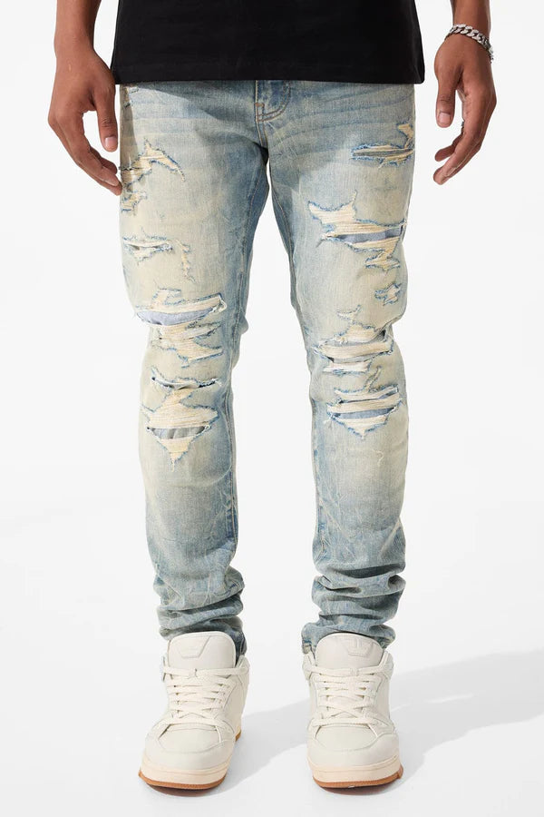  Slim taper fit jeans with rip-and-repair design, fused shreds, and unique vintage distressing