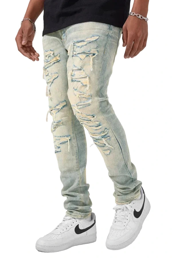 Slim taper fit denim jeans with rip-and-repair detailing and vintage-inspired distressing.