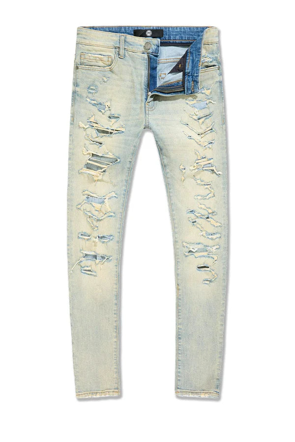 Slim taper fit denim jeans with rip-and-repair detailing and vintage-inspired distressing.